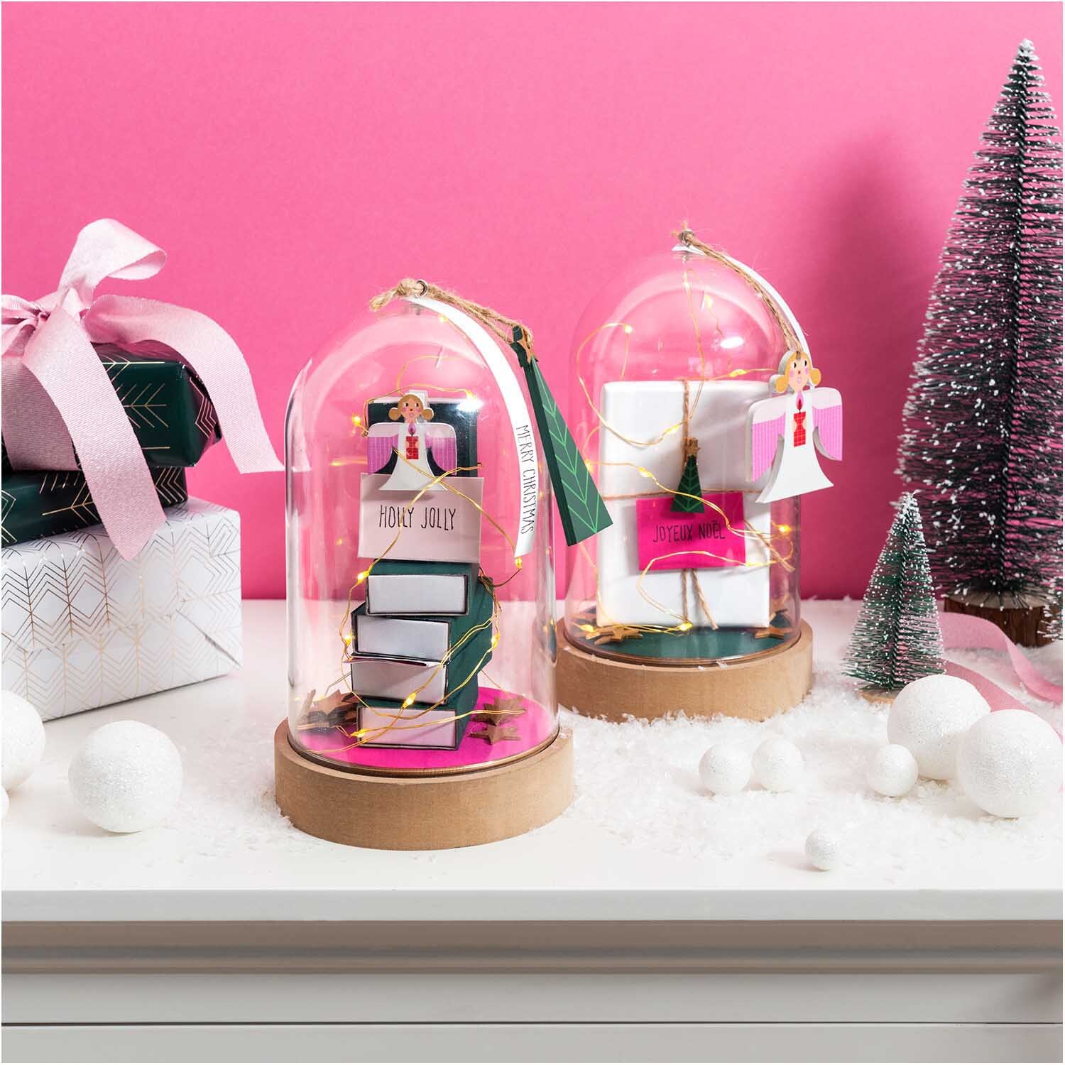 Streichholzschachtelset groß 11x6,3x2cm weiß 12 Stück von Rico Design Streichholzschachtelset groß von Rico Design in dekorativen Glaskuppeln, umgeben von festlichen Geschenken und Miniaturbäumen.