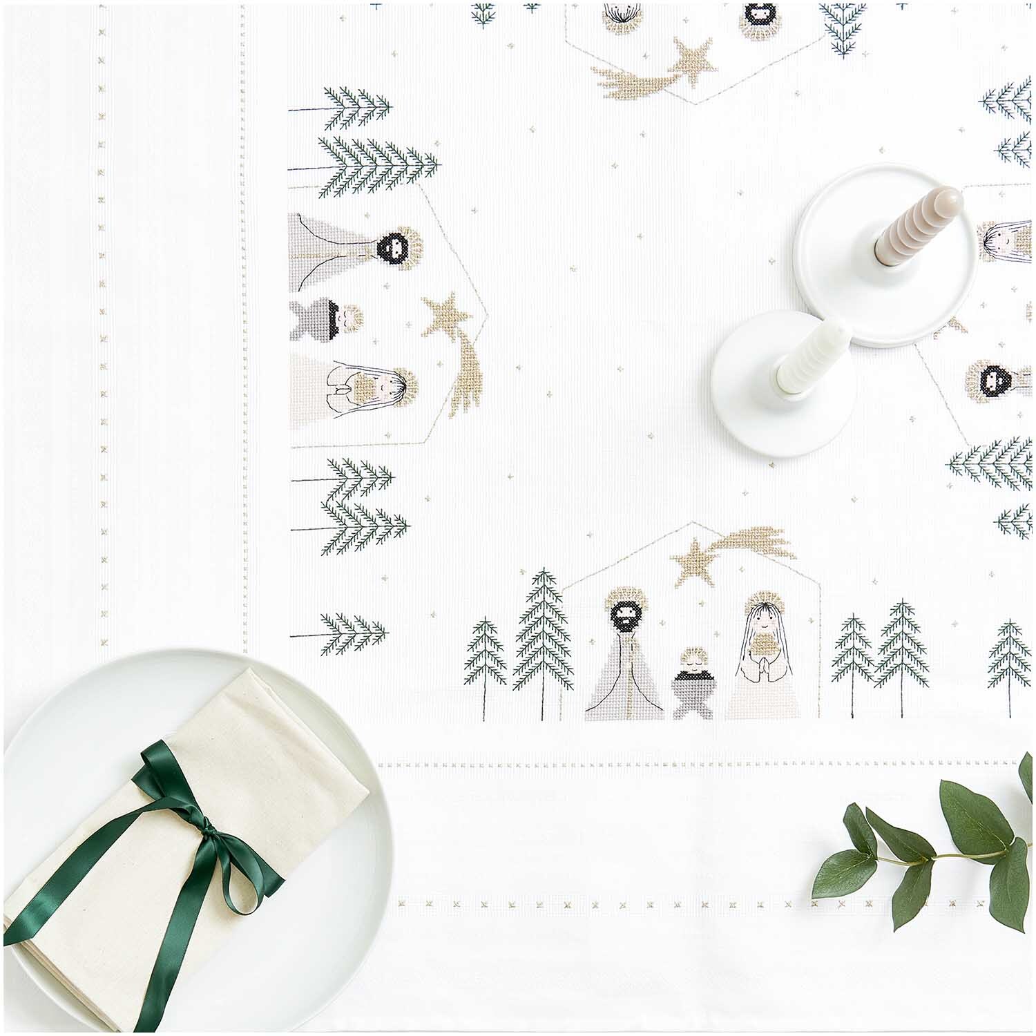Stickpackung Tischdecke Krippe 90x90cm zeigt eine weihnachtliche Szene mit Krippenfiguren und Tannenbäumen, ideal für festliche Dekorationen.