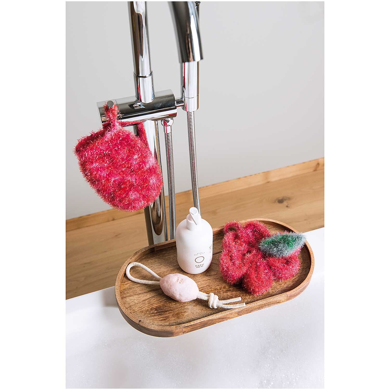 Creative Bubble Print: Strickschwämme in verschiedenen Farben auf einem Holztablett neben einem Wasserhahn. Ideal für kreative Reinigungsprojekte.