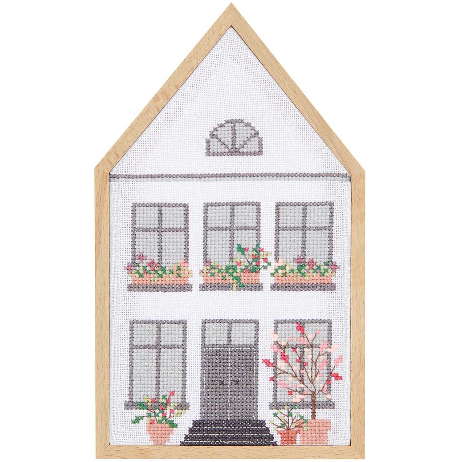 Cadre décoratif Maison format portrait Taille 16x27cm from Rico Design Dekorahmen Haus Hochformat von Rico Design zeigt ein gesticktes Haus mit Blumen in einem Holzrahmen.