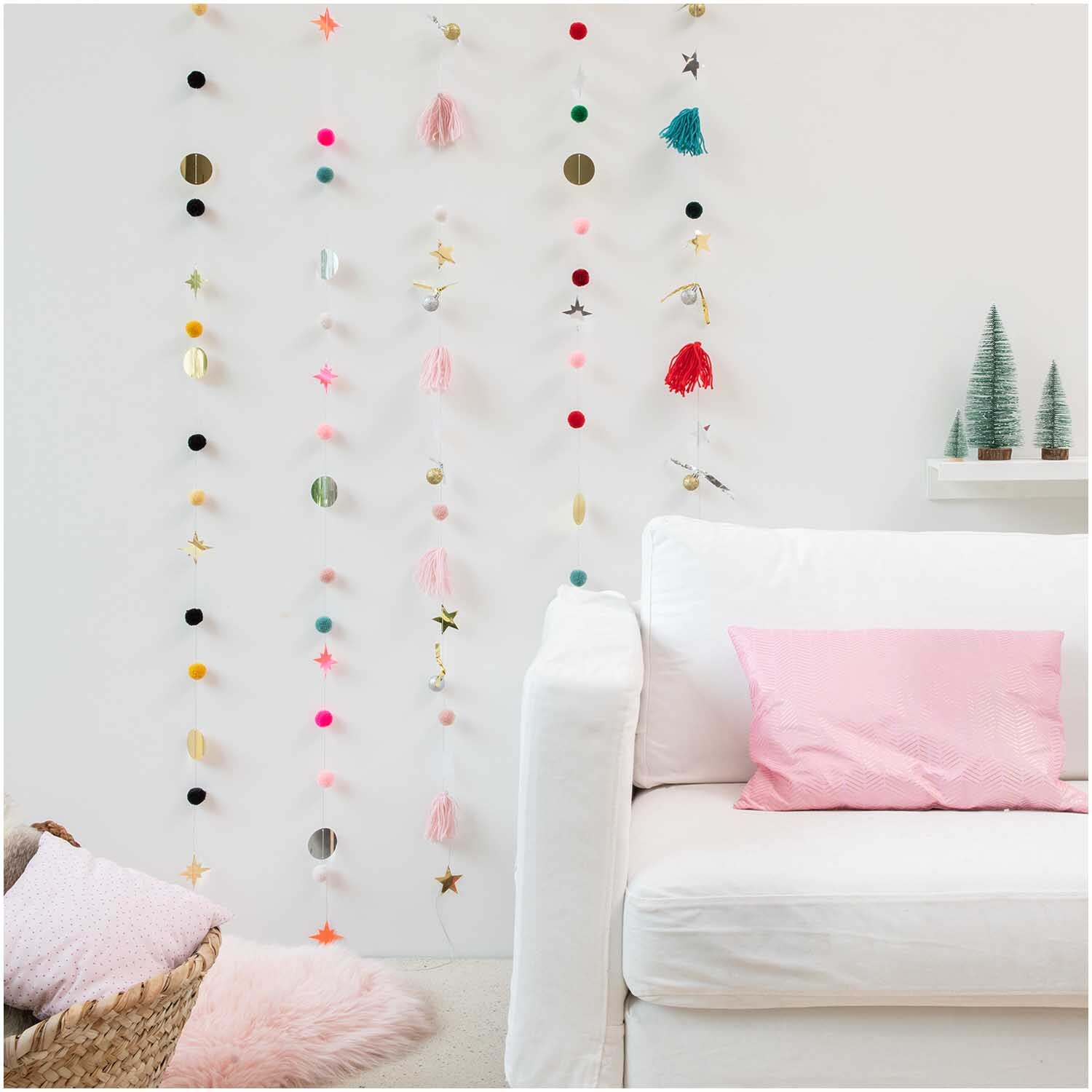 Quasten-Girlande gold-schwarz 2,2m von Rico Design Quasten-Girlande gold-schwarz 2,2m von Rico Design, dekorativ an einer weißen Wand mit bunten Elementen.