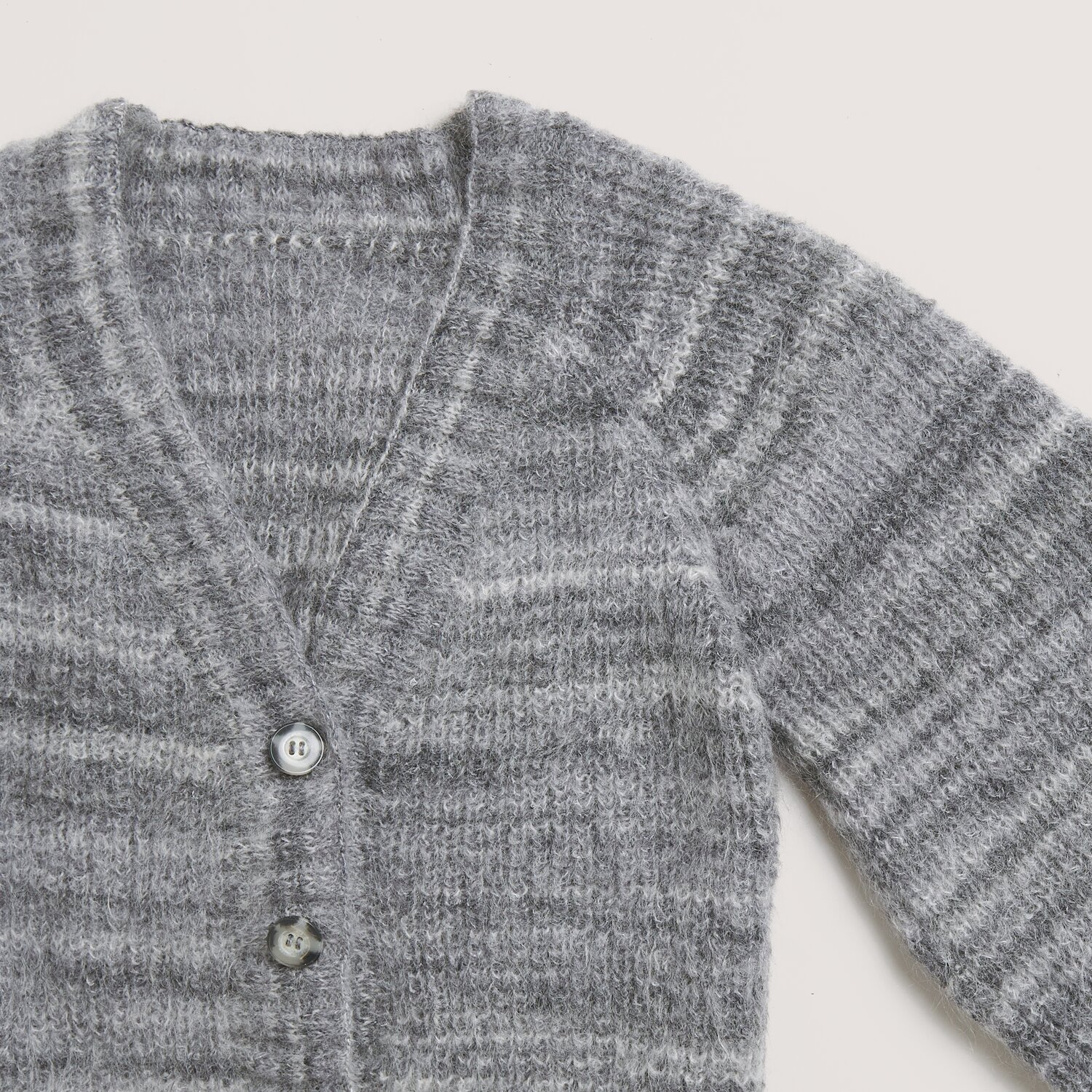 Fashion Meri Mohair Print 50g 275m Couleur Gris pierre from Rico Design Fashion Meri Mohair Print: Grauer Strickpullover mit V-Ausschnitt und Knöpfen, aus weichem Material von Rico Design. Ideal für kühle Tage.