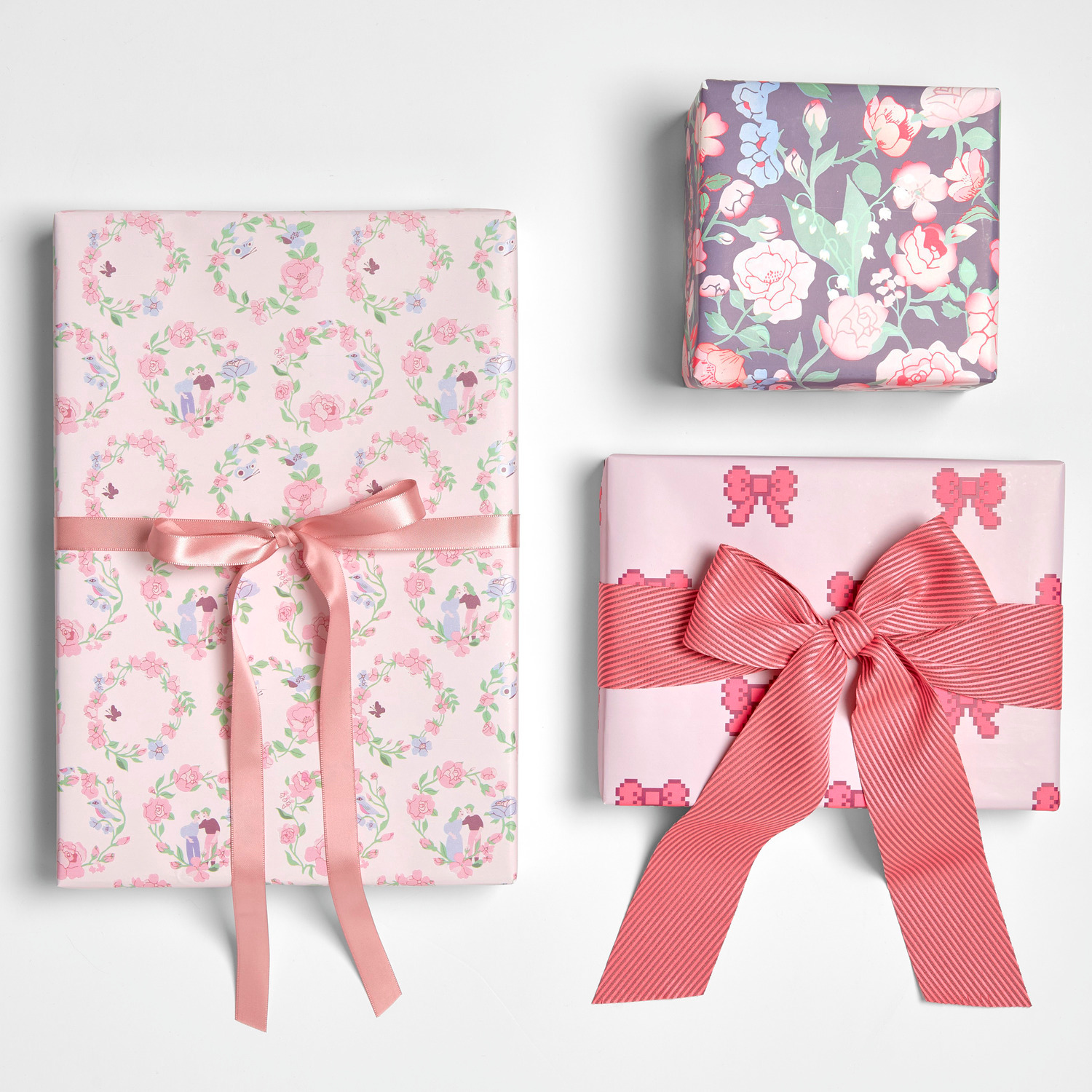Geschenkpapier Rosen Kränze 200x70cm 80g/m² von Rico Design Geschenkpapier Rosen Ranken: Drei Geschenke in zarten Rosatönen mit floralen Mustern und Schleifen.