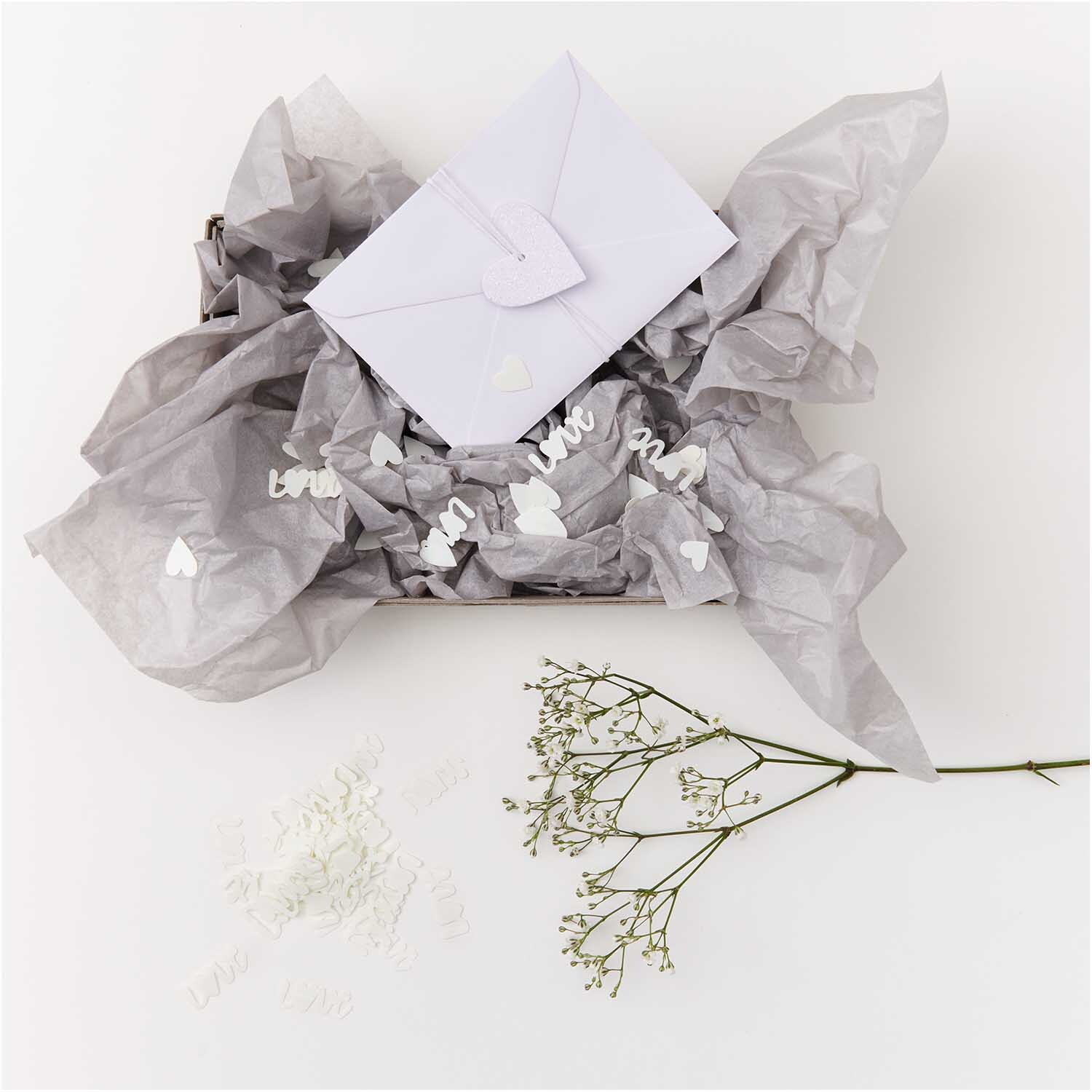 Flitter Love Creme: Weiße Papierherzen von Rico Design, dekorativ auf Seidenpapier arrangiert.