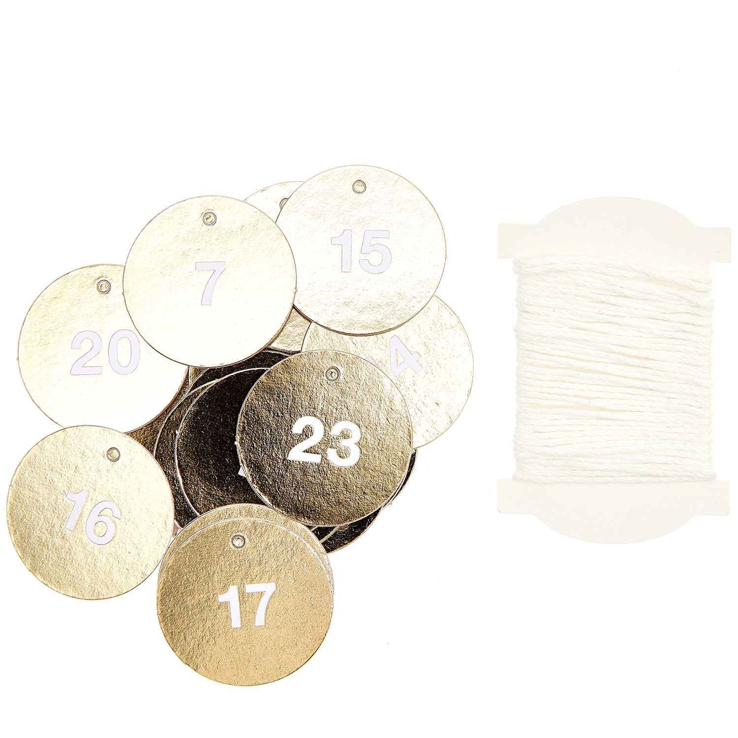 Paper Poetry Adventskalenderanhänger, 24 goldene Kreise von Rico Design, mit Zahlen bedruckt, neben weißem Faden.