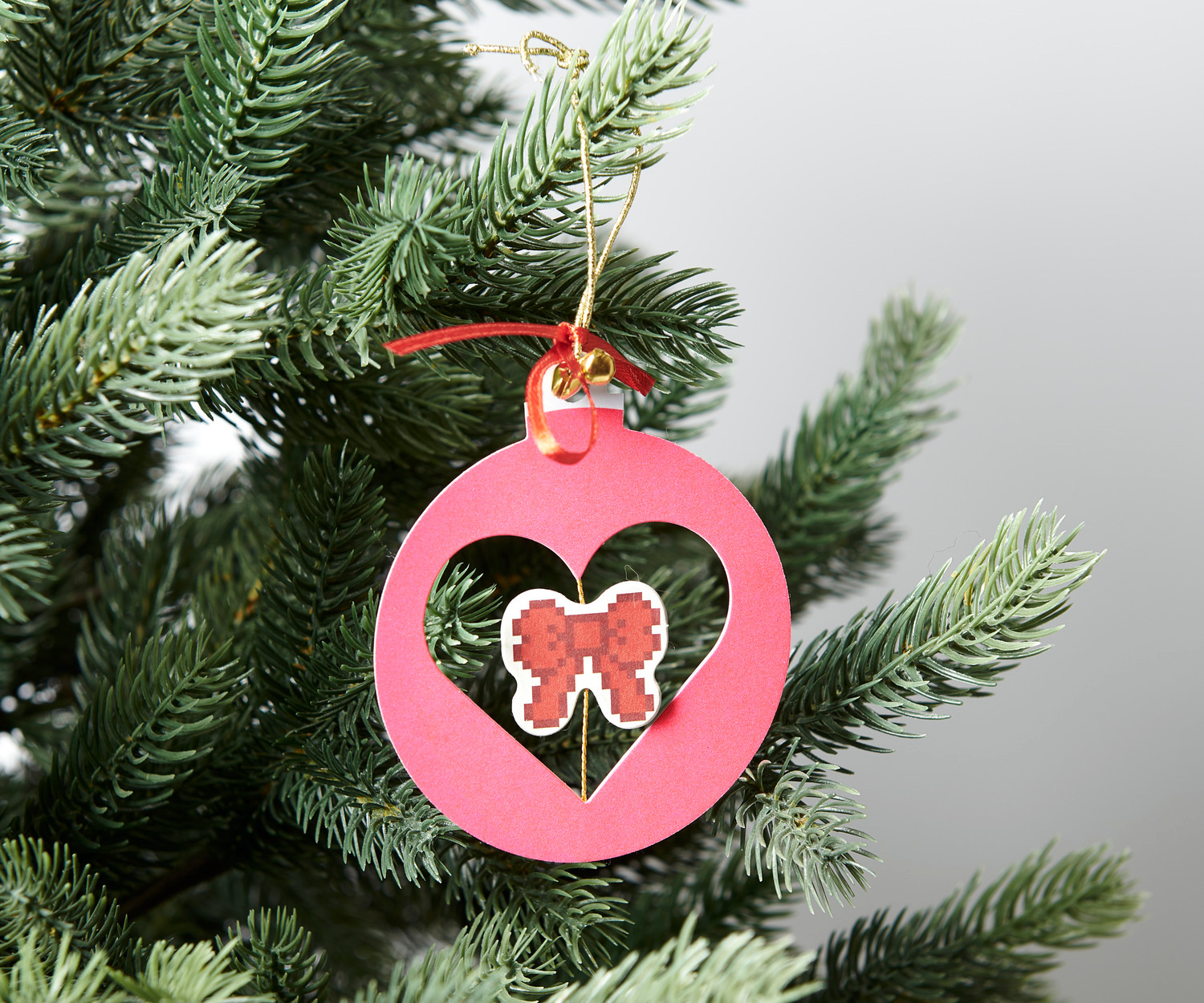 Paper Poetry Papierornament Neonpink Ø7,5x9cm von Rico Design Paper Poetry Papierornament in Herzform mit Schleifenmotiv, hängend an einem Tannenzweig.