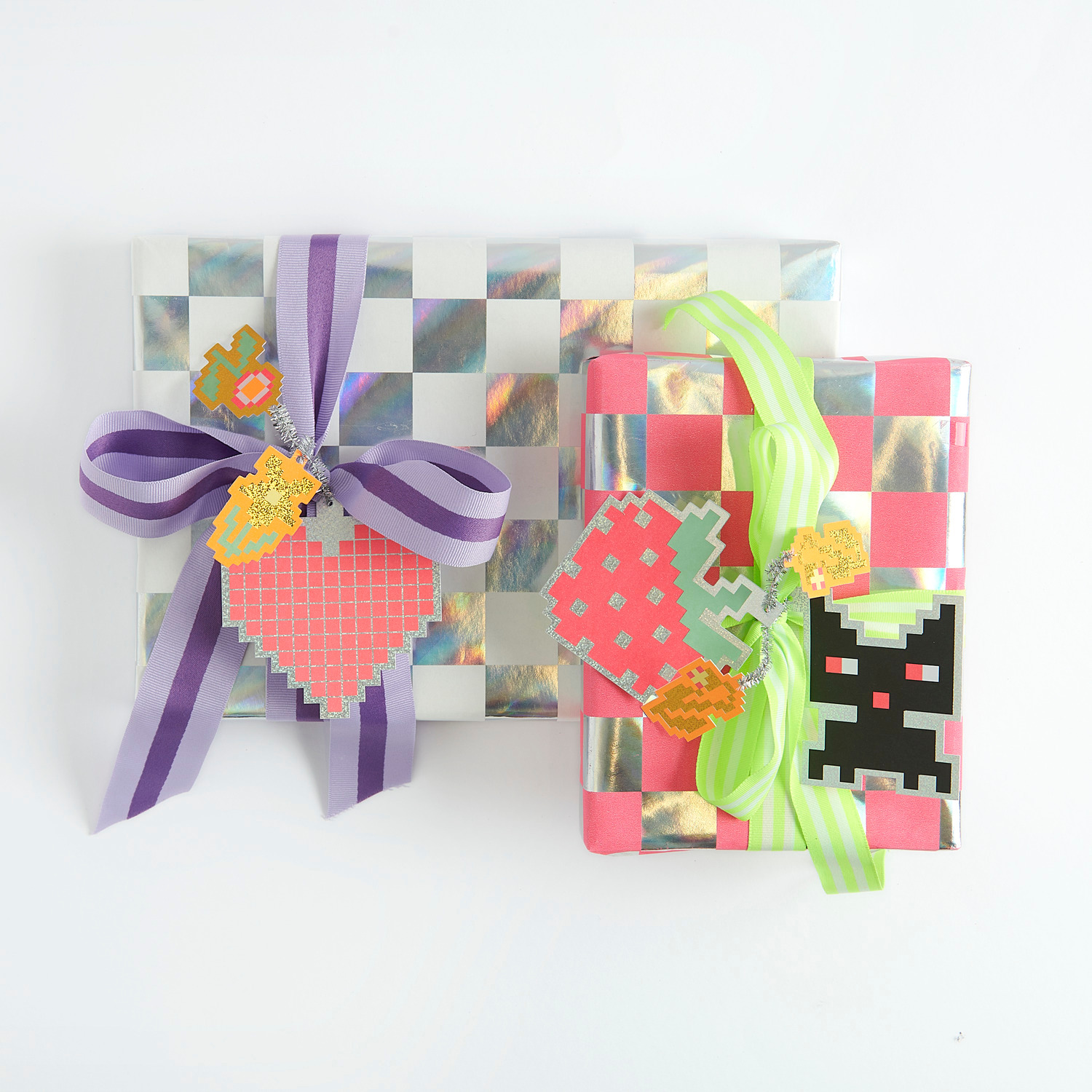 Paper Poetry Papier cadeau échiquier 200x70cm 80g/m Couleur Blanc from Rico Design Paper Poetry Webband Duo Streifen Neon: Zwei Geschenke mit Schachbrettmuster und bunten Bändern, dekoriert mit floralen Anhängern.