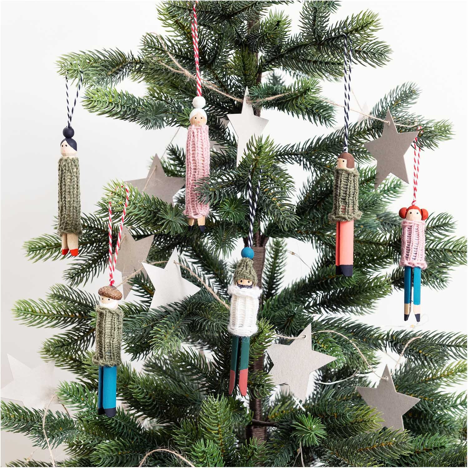 Paper Poetry Papieranhänger Stern an einem Weihnachtsbaum mit handgefertigten Puppen und Graukarton. Ideal für festliche Dekorationen.