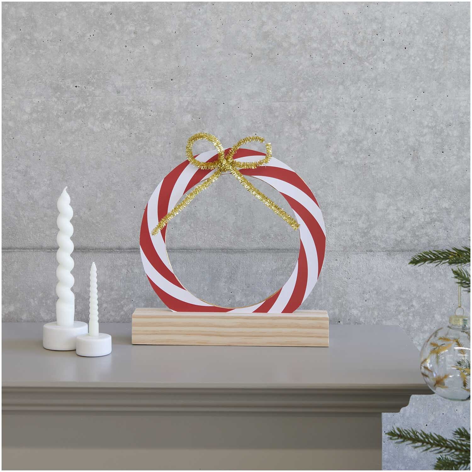 Paper Poetry Kartonring Candy Cane Ø 25cm von Rico Design Paper Poetry Kartonring Candy Cane Ø 25cm von Rico Design auf einem Regal mit Kerzen und Dekoration.
