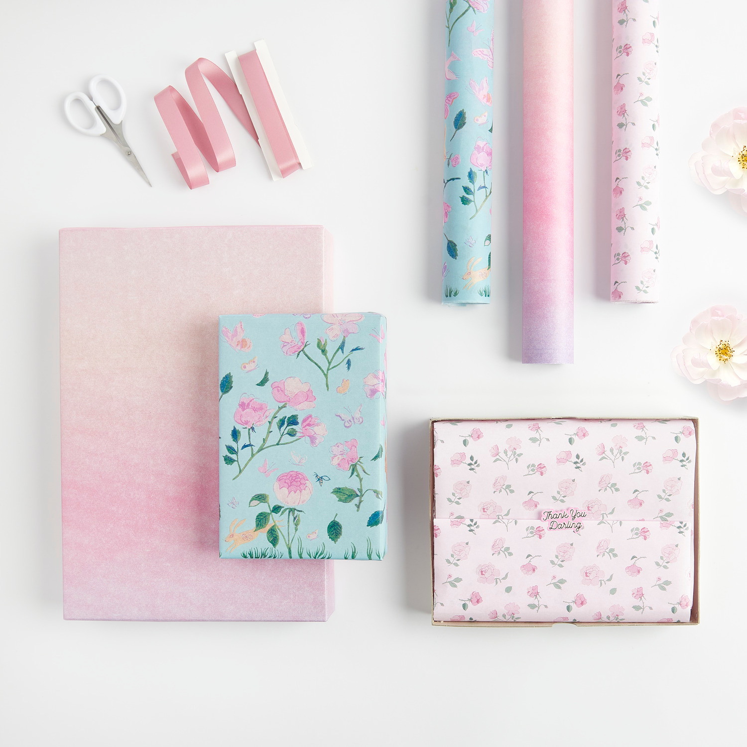 Seidenpapier Farbverlauf Rosa 4m 28g/m² von Rico Design Seidenpapier Farbverlauf Rosa von Rico Design, dekoriert mit floralen Mustern und rosa Bändern, ideal für kreative Geschenkverpackungen.