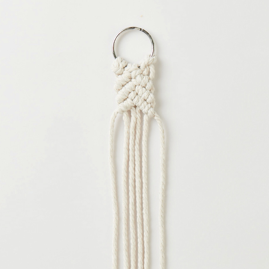 Set de macramé porte-clés 3 pièces from Rico Design Makramee Set Schlüsselanhänger von Rico Design: Handgefertigter weißer Anhänger mit geflochtenem Muster und Metallring. Ideal für kreative Projekte.