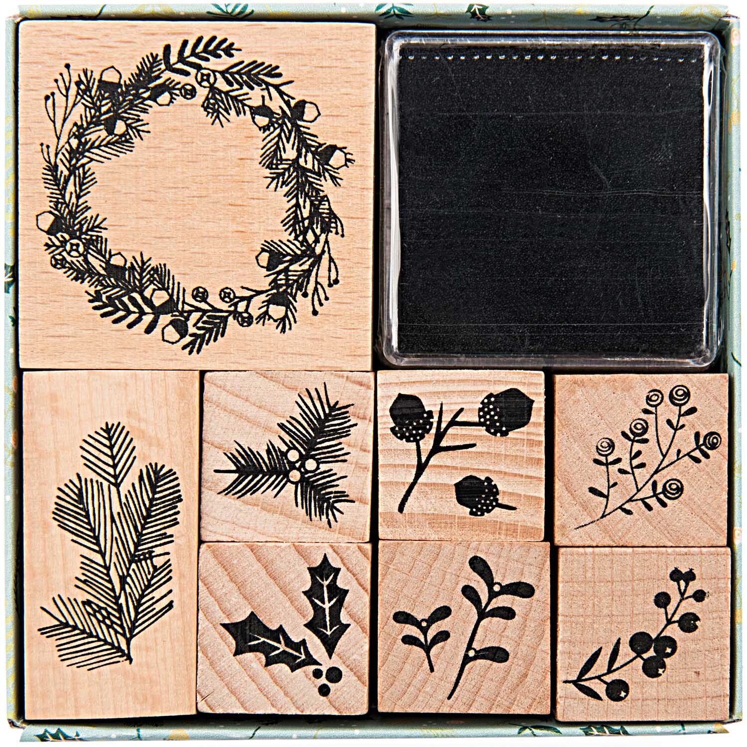 Paper Poetry Stempelset Classical Christmas mit acht Holzstempeln und schwarzem Stempelkissen. Enthält weihnachtliche Motive wie Kränze und Zweige.