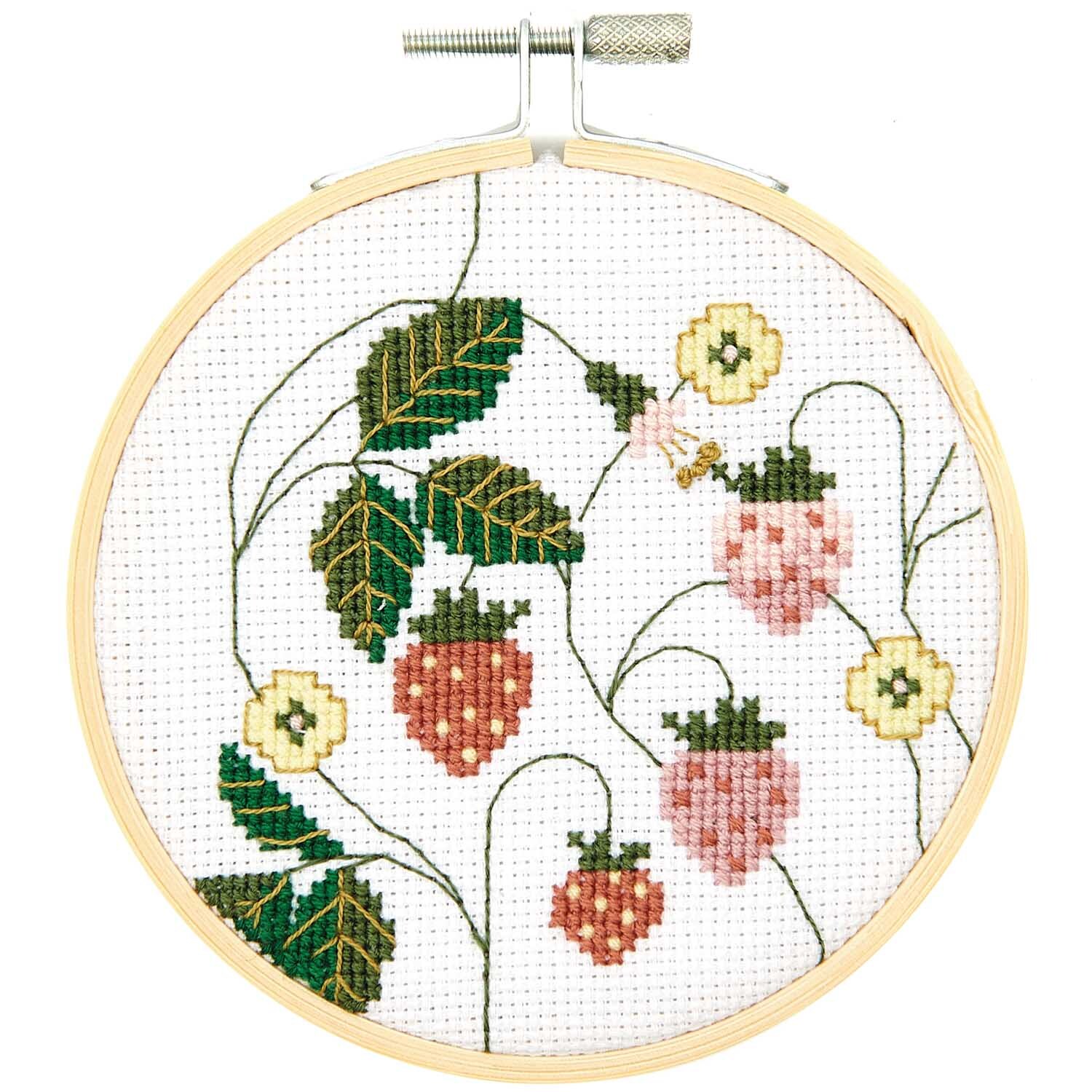 Stickpackung Bild Erdbeeren Ø10cm zeigt gestickte Erdbeeren und Blätter in einem runden Stickrahmen. Marke: Rico Design.