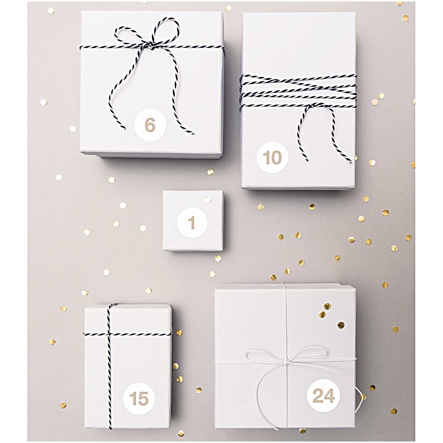 Paper Poetry Adventskalender Sticker Zahlen 1-24 auf weißen Geschenken mit schwarzem Band dekoriert.