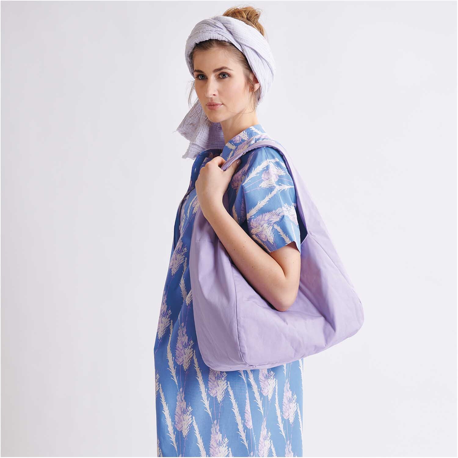 Meterware Krinkelmusselin hellgrau Hot Foil von Rico Design Meterware Krinkelmusselin hellgrau Hot Foil: Frau in blauem Kleid mit lila Tasche und Kopftuch. Stoff von Rico Design.