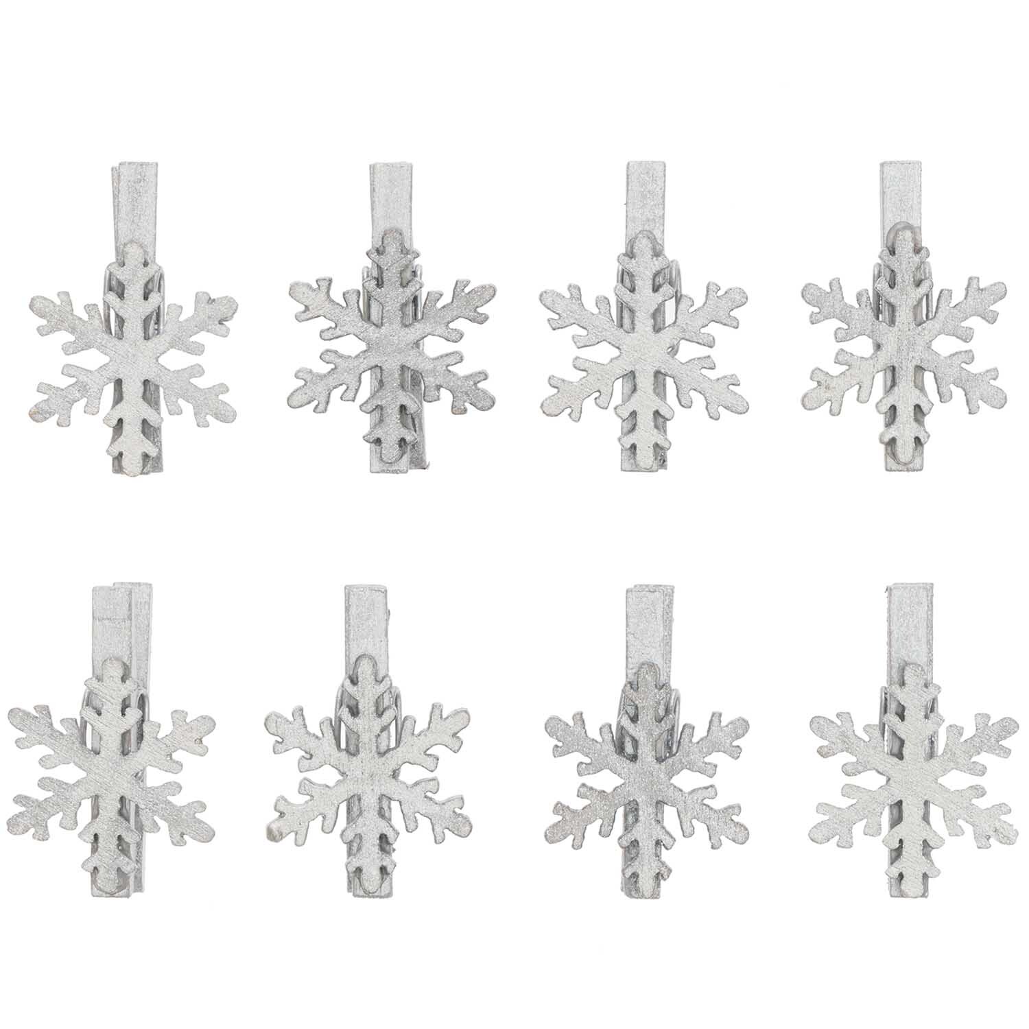 Dekoklammern Schneeflocke silber 3cm 8 Stück von Rico Design, zeigen acht silberne Schneeflockenklammern auf schwarzem Hintergrund.