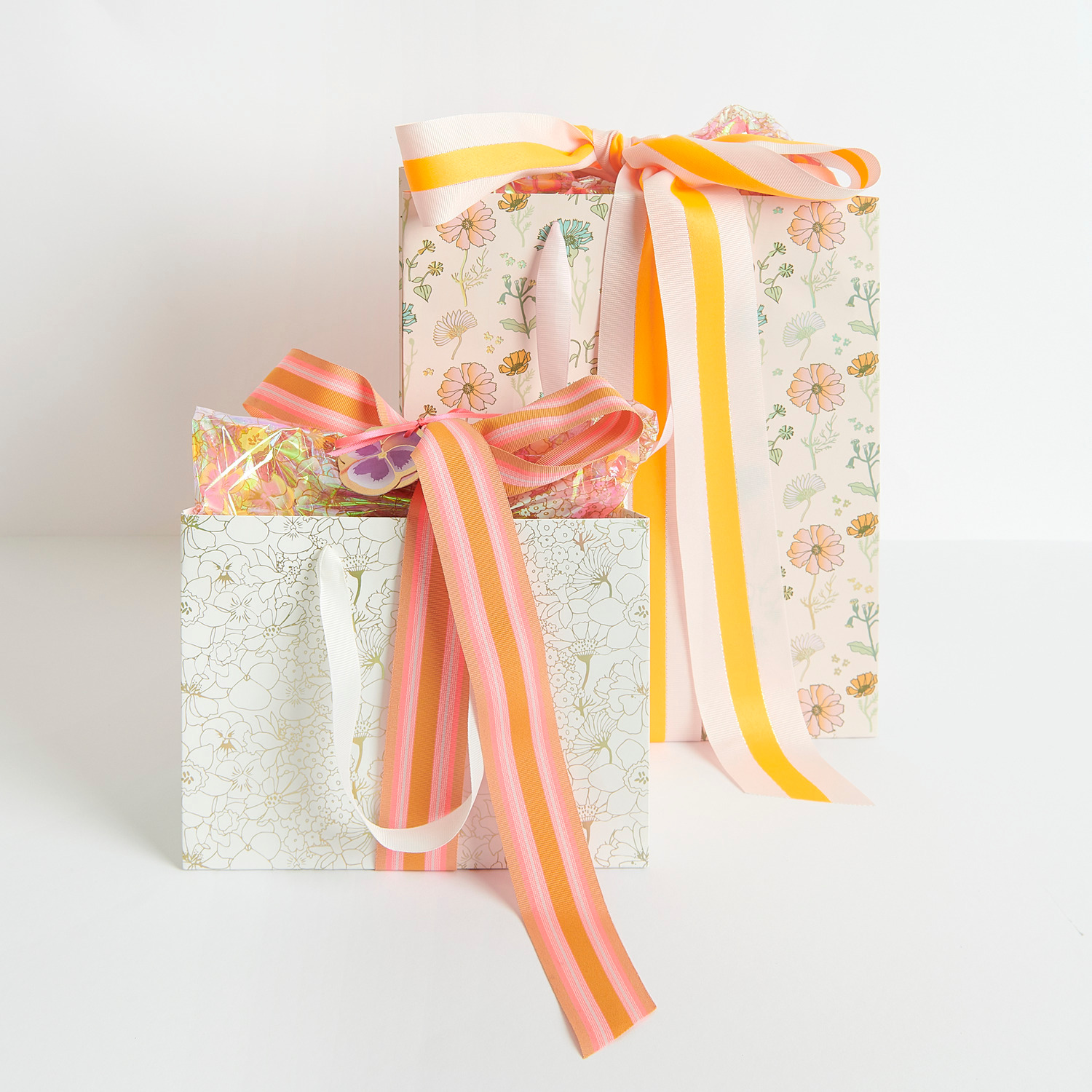 Webband Multi Streifen: Zwei Geschenktüten mit floralen Mustern und farbigen Bändern von Rico Design.