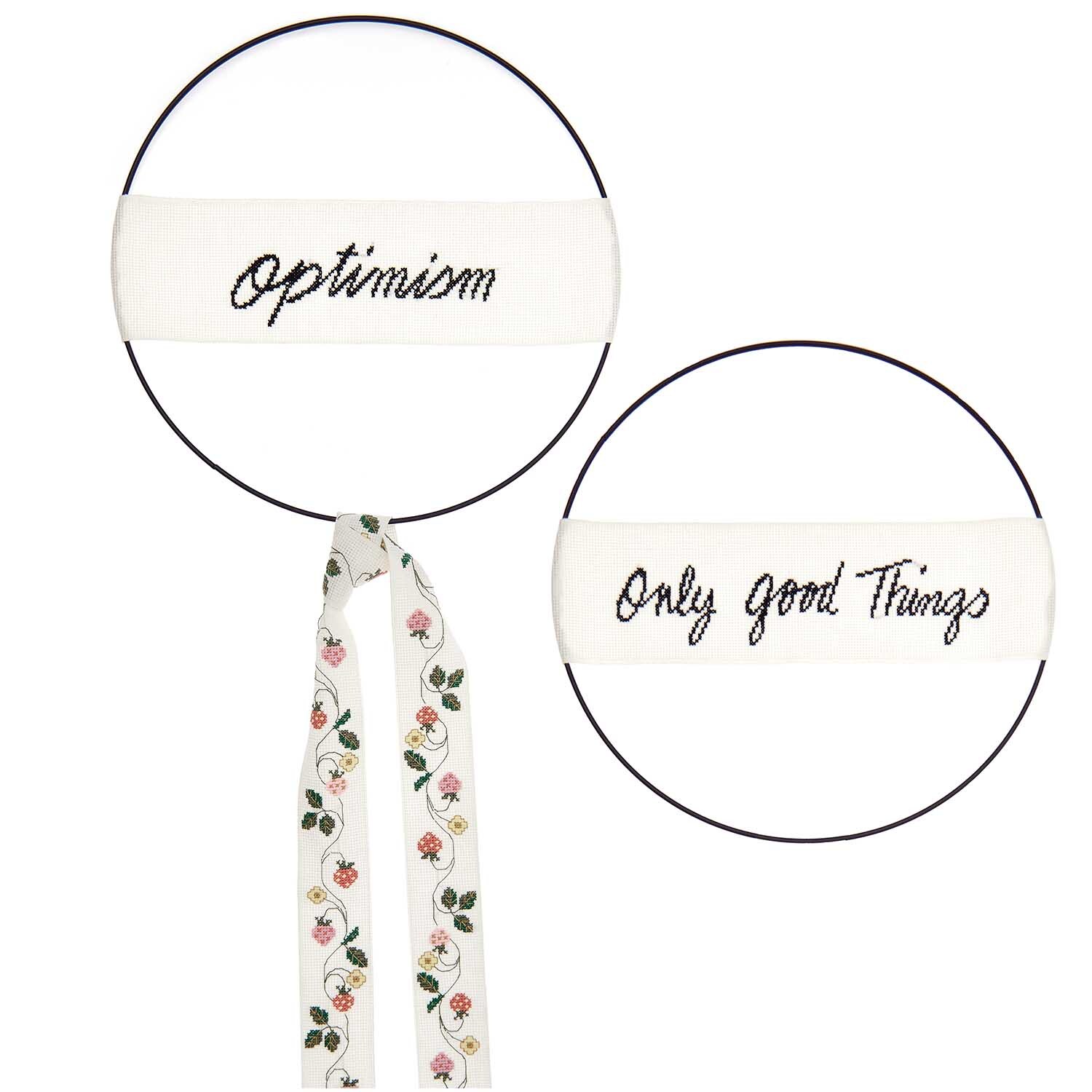 Stickpackung Band Optimism und Band Erdbeerranke zeigt bestickte Bänder mit positiven Botschaften und Erdbeermuster von Rico Design.