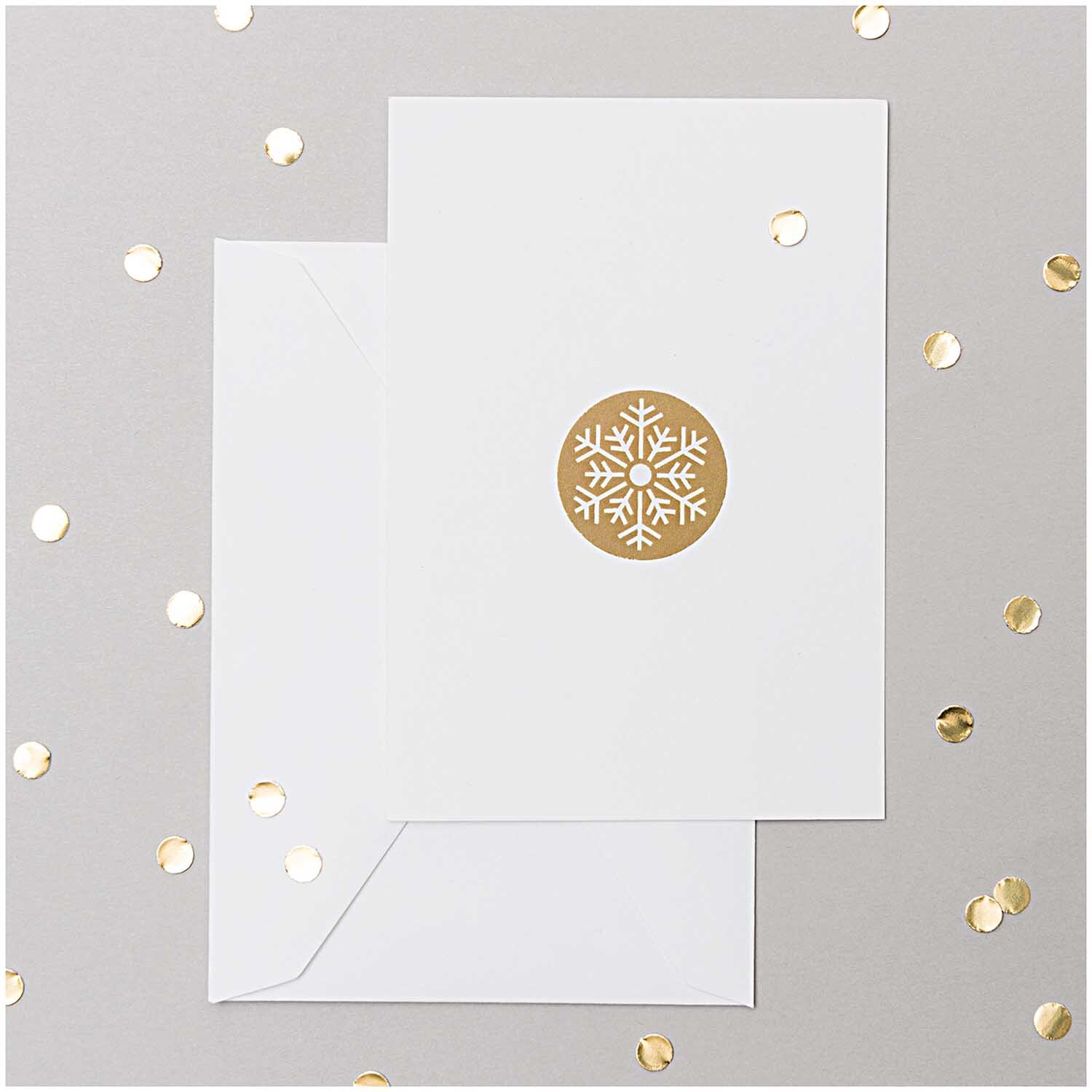 Paper Poetry Kartenset Basic weiß A7/C7 30-teilig von Rico Design Paper Poetry Kartenset Basic weiß A7/C7, 30-teilig, zeigt eine Karte mit goldener Schneeflocke auf weißem Hintergrund, umgeben von goldenen Punkten.
