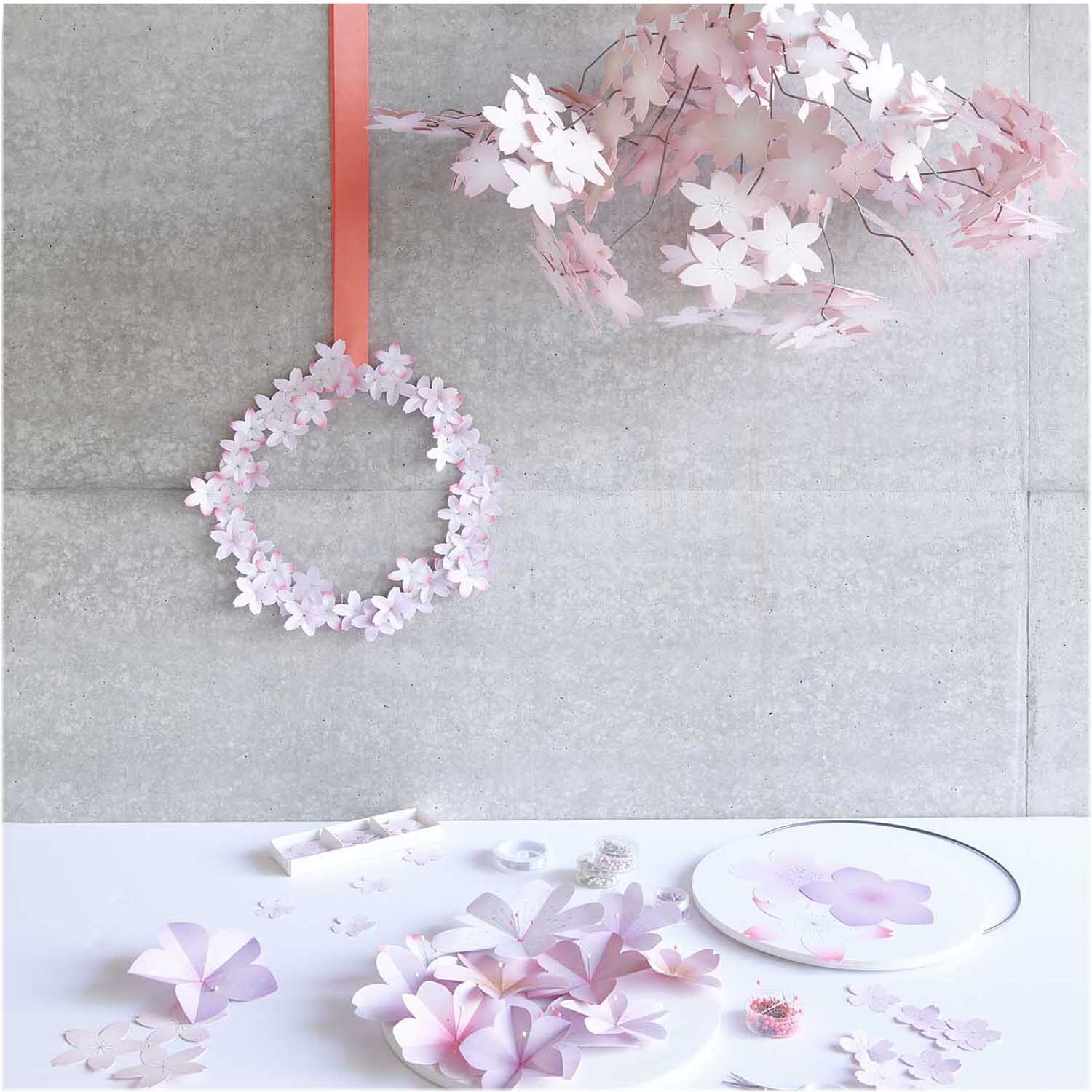 Paper Poetry Papierblüten Luxury Sakura in Rosa, dekorativ arrangiert auf einem Tisch mit Kranz.