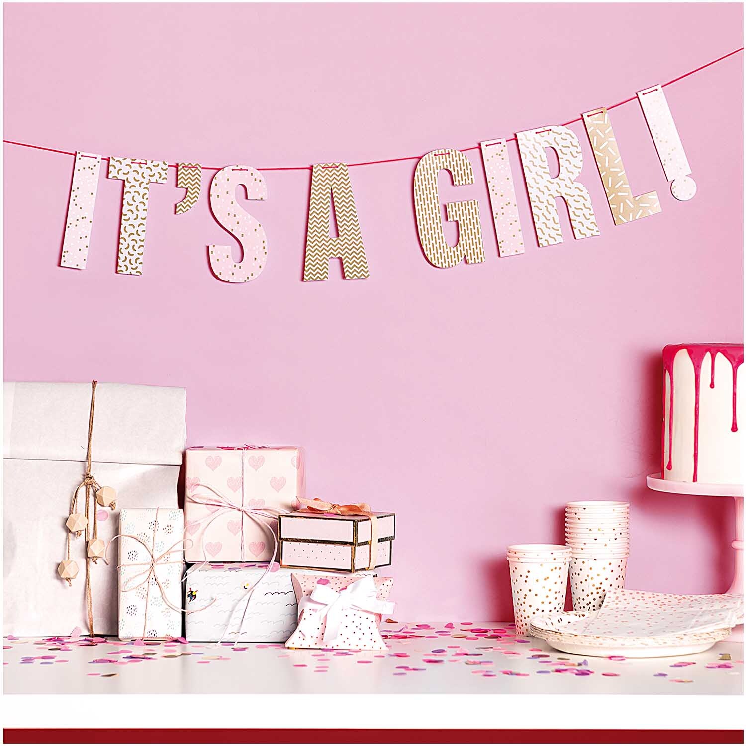 Girlande It's a girl 3m: Rosa Girlande mit Schriftzug, umgeben von Geschenken und Partydeko. Ideal für Babypartys. Marke: Rico Design.