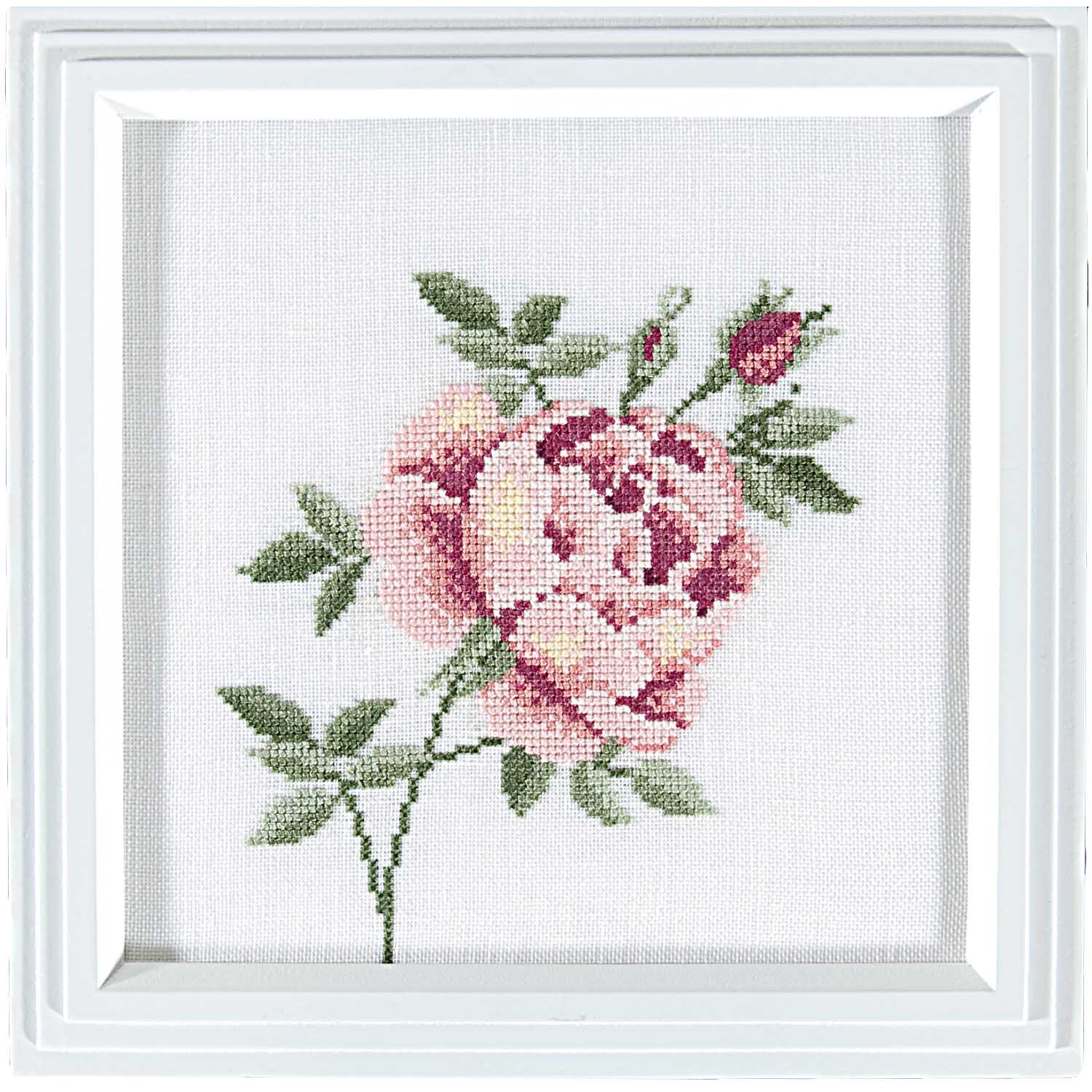 Stickpackung Rose 21x21cm zeigt eine gestickte rosa Rose mit grünen Blättern in einem weißen Rahmen. Marke: Rico Design.