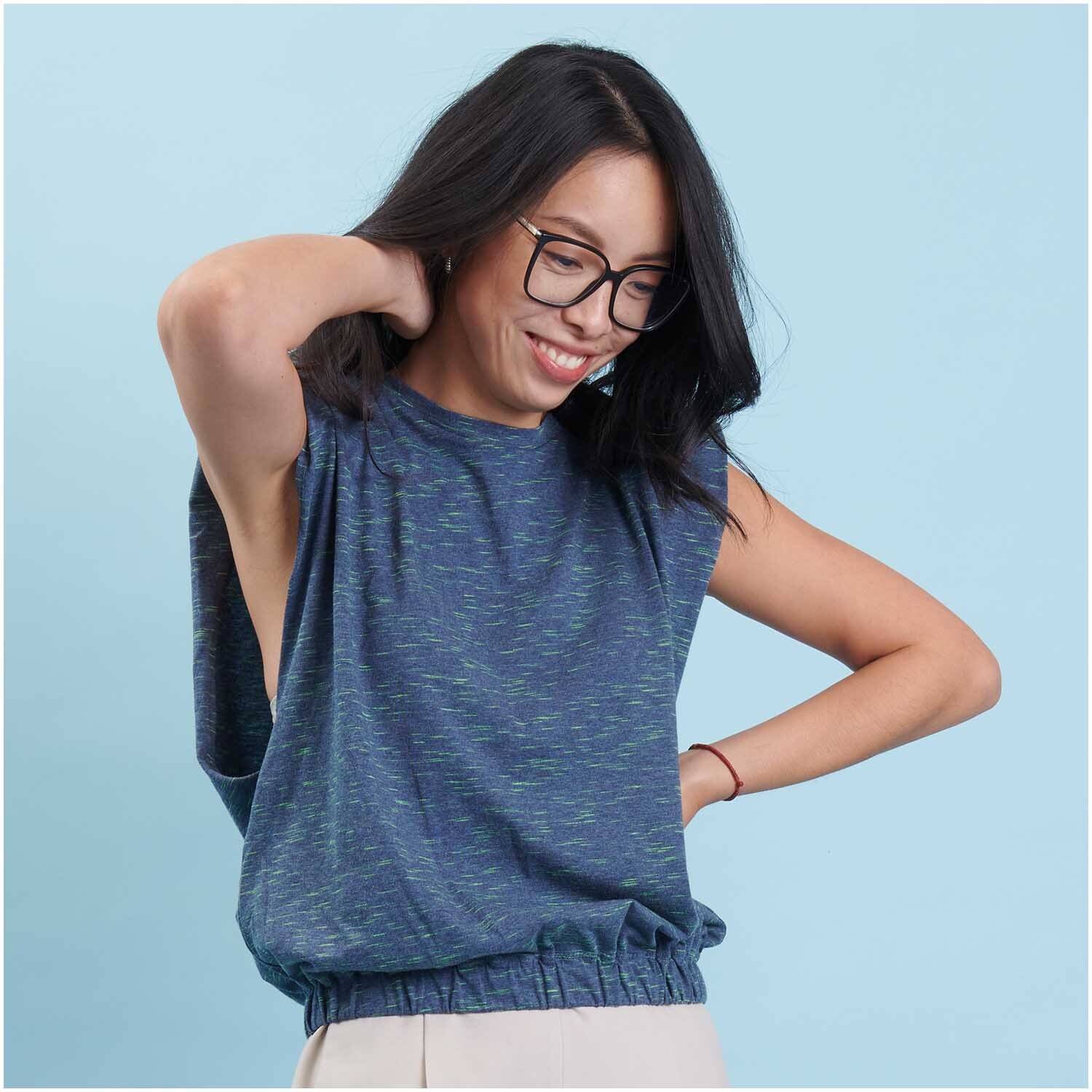 Stoffabschnitt Jersey dunkel blau/neon grün 80x100cm von Rico Design Stoffabschnitt Jersey in Blau und Grün von Rico Design, getragen von einer lächelnden Frau.