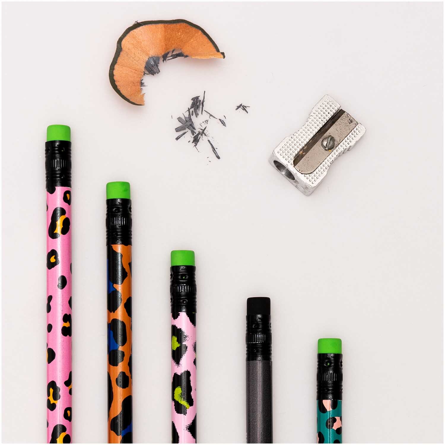 Paper Poetry Bleistifte Acid Leo 4er-Set von Rico Design Paper Poetry Bleistifte Acid Leo 4er-Set mit buntem Leopardenmuster und grünem Radiergummi, daneben ein Anspitzer und Späne.