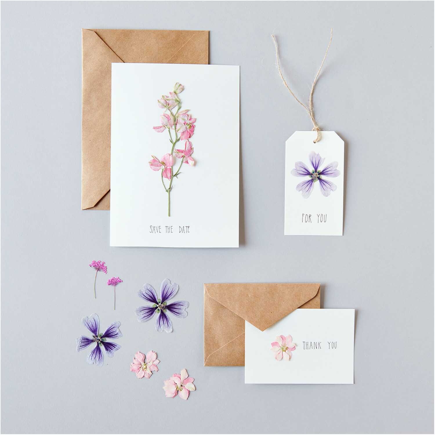 Gepresste Blüten Mix Set rosa-violett 11 Stück von Rico Design Gepresste Blüten Mix Set rosa-violett 11 Stück auf Karten und Anhänger, dekorativ arrangiert.