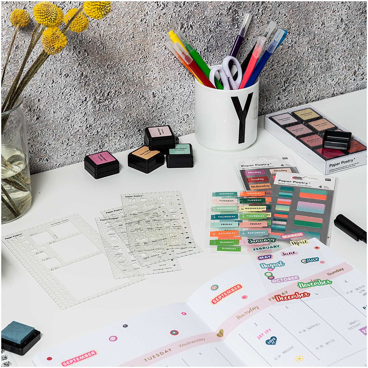 Paper Poetry Bullet Diary Schablonen auf einem Schreibtisch mit Stiften, Notizblöcken und Stempeln. Ideal für kreative Planer und Organisatoren.