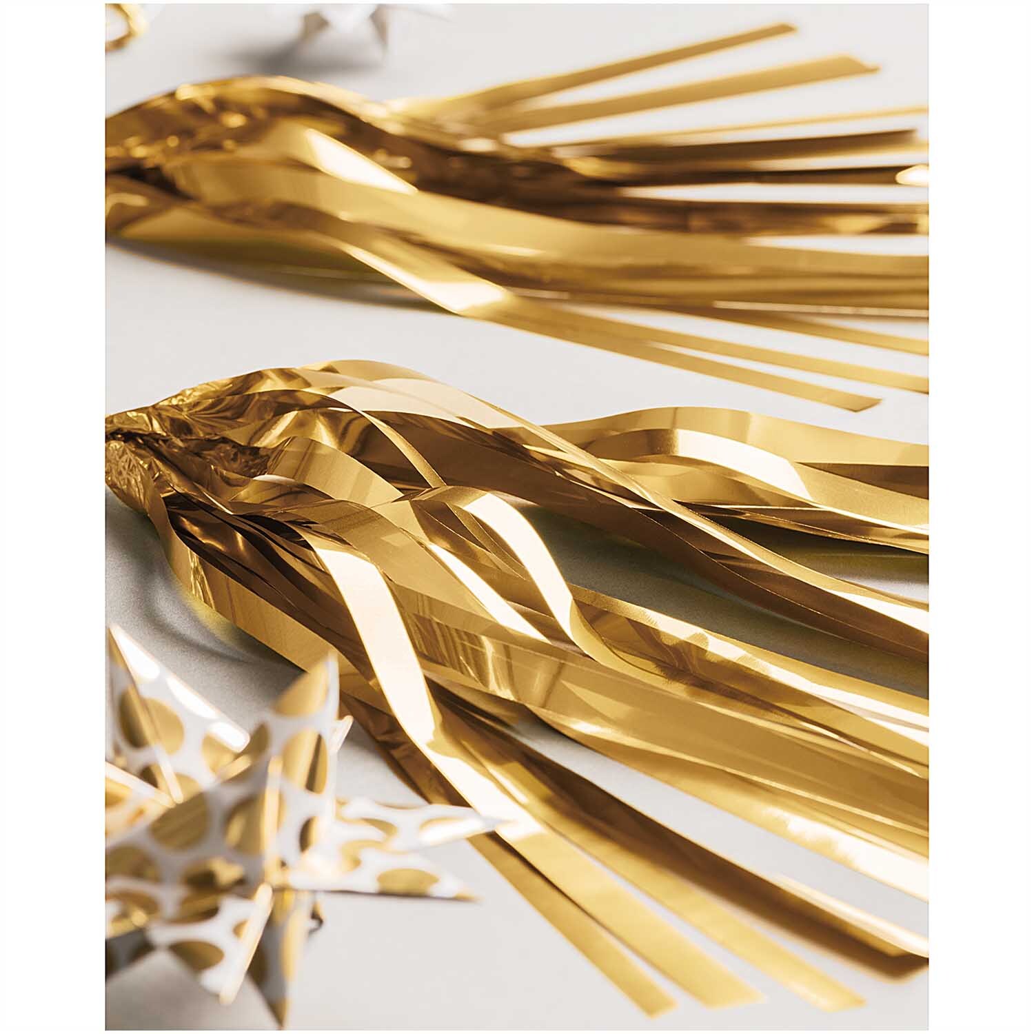 Paper Poetry Girlande Quasten gold 2,8m von Rico Design Paper Poetry Girlande Quasten in glänzendem Gold von Rico Design, dekorativ arrangiert auf einem Tisch. Ideal für festliche Anlässe.
