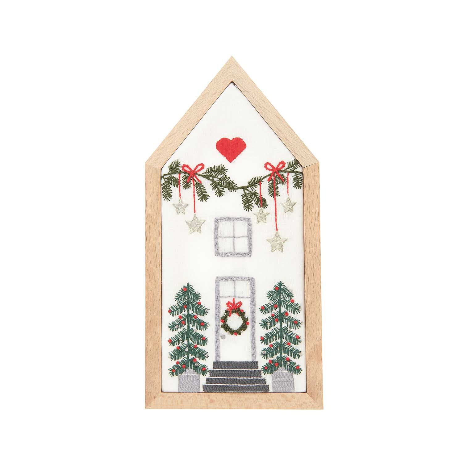 Stickpackung Haus klein vorgezeichnet 9x18cm zeigt ein gesticktes Haus mit Herz, Girlanden und Bäumen, von Rico Design.