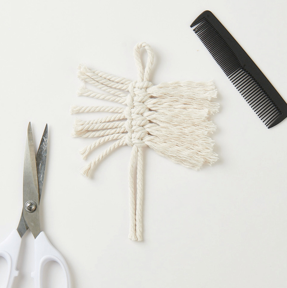 Set de macramé feuilles 3 pièces from Rico Design Makramee Set Blätter, 3 Stück: Weiße Makramee-Blätter mit Schere und Kamm auf hellem Hintergrund. Ideal für DIY-Projekte.