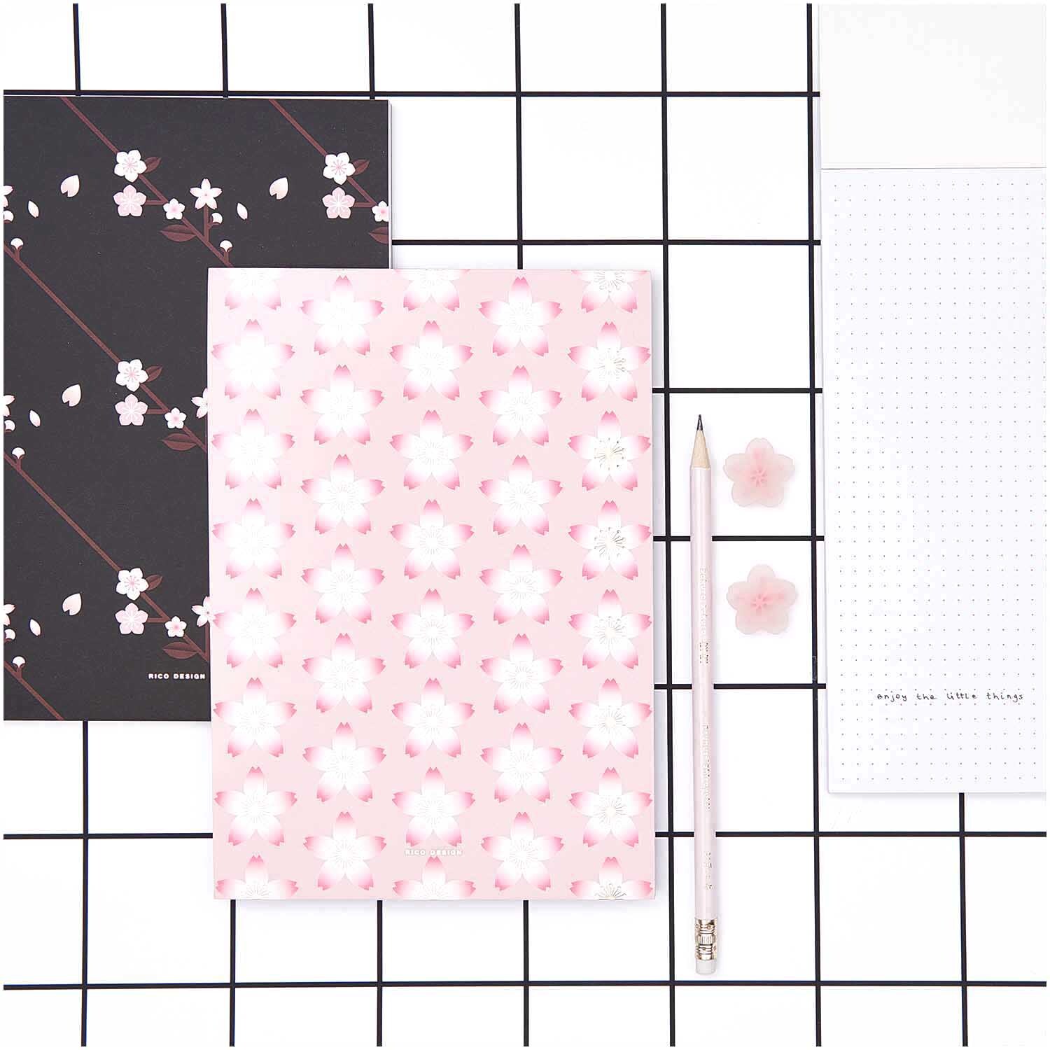 Paper Poetry Notizblock Kirschblüten pink A5 50 Blatt 100g/m² von Rico Design Paper Poetry Notizblock mit Kirschblütenmuster, A5, 50 Blatt, 100g/m², von Rico Design, auf einem karierten Hintergrund mit passendem Stift.