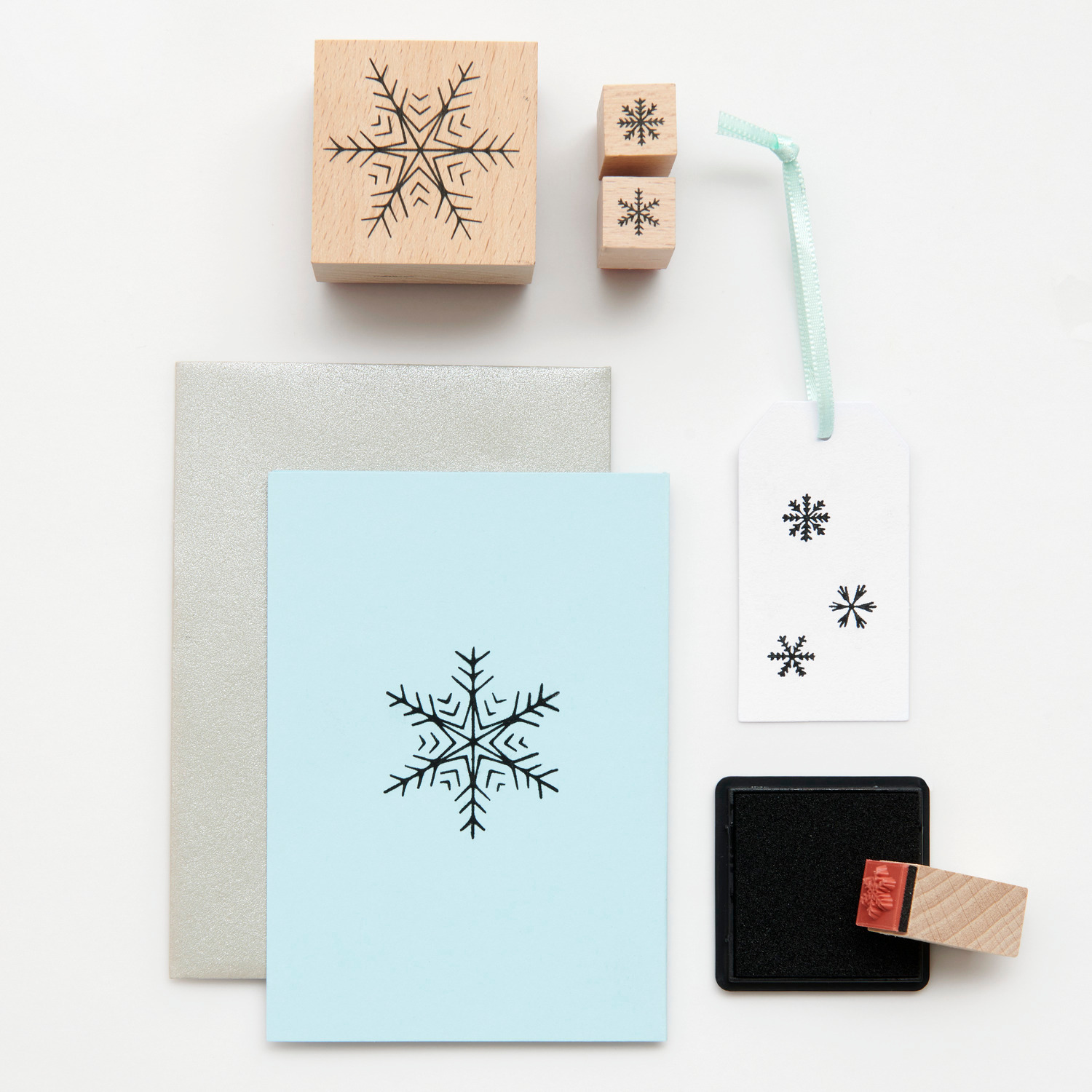 Paper Poetry Stempelset Schneeflocken, 13-teilig, mit blauer Karte, Holzstempeln und Stempelkissen. Ideal für kreative Winterprojekte.
