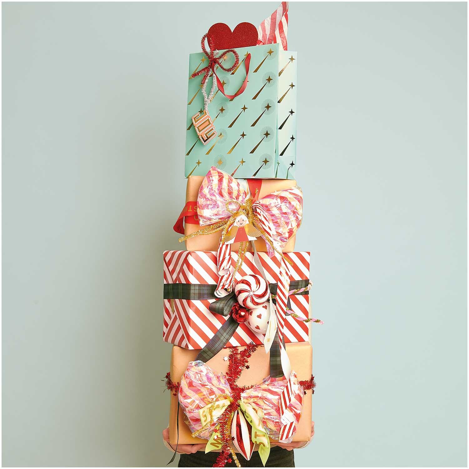 Paper Poetry Geschenkanhänger Christmas Figuren 8 Stück: Bunte Geschenke mit Schleifen und Anhängern, dekoriert in festlichen Farben.