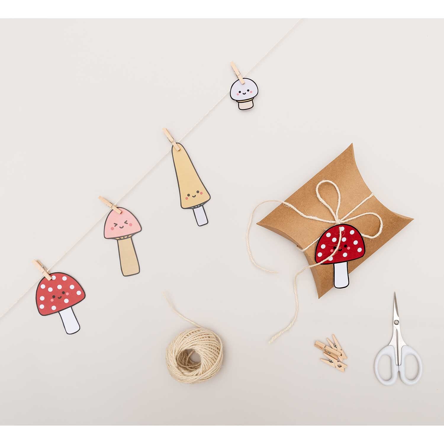 Paper Poetry Papieranhänger Kawaii-Pilze 8 Stück von Rico Design Paper Poetry Papieranhänger Kawaii-Pilze 8 Stück: Mehrfarbige Pilzanhänger an einer Schnur, dekorativ mit Schere und Geschenkbox arrangiert.