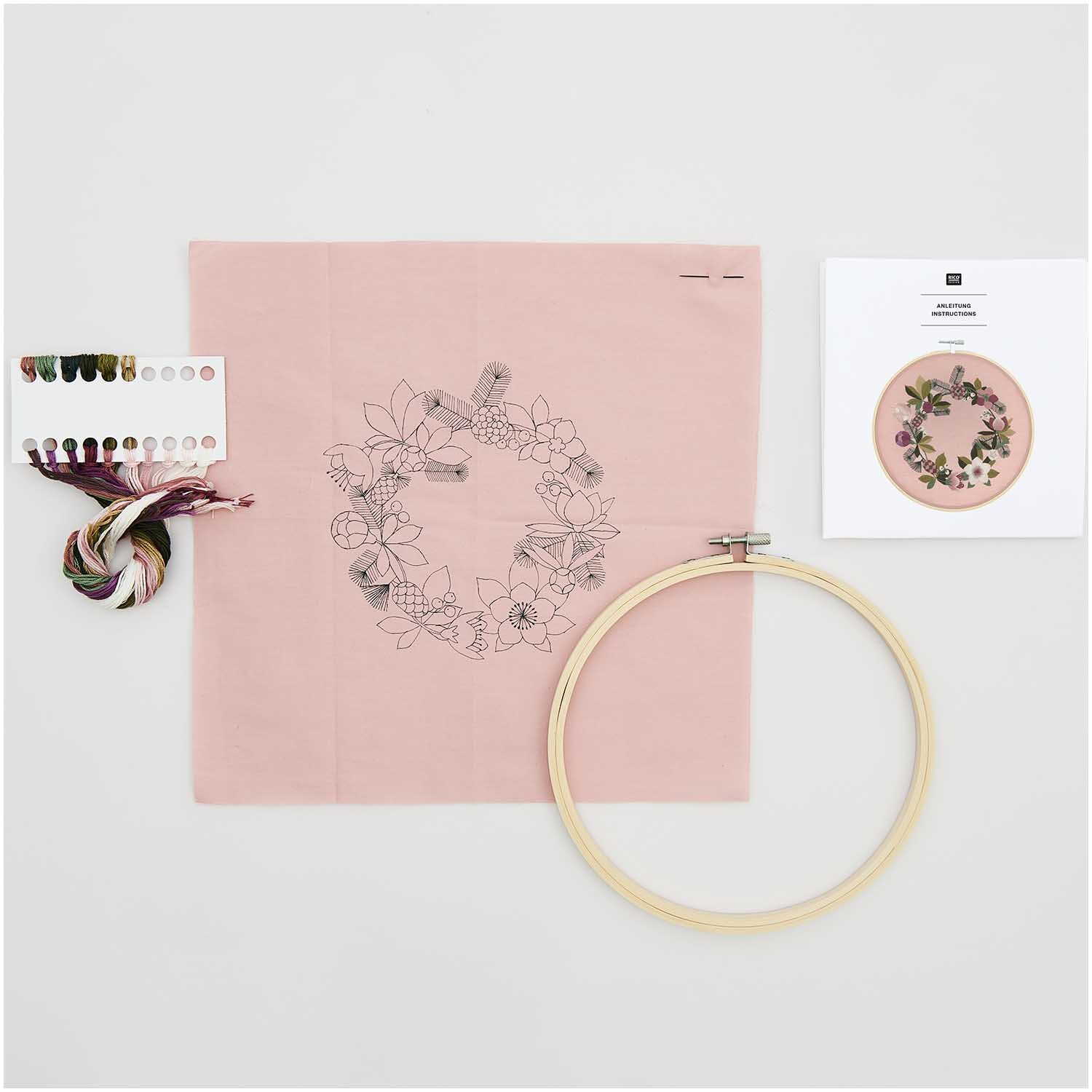 Paquet de broderie Image Roses de Noël pré-dessinée Ø20,5cm from Rico Design Stickpackung Bild Christrosen vorgezeichnet von Rico Design: Stickrahmen, Garn und Anleitung auf rosa Stoff. Perfekt für kreative Projekte.