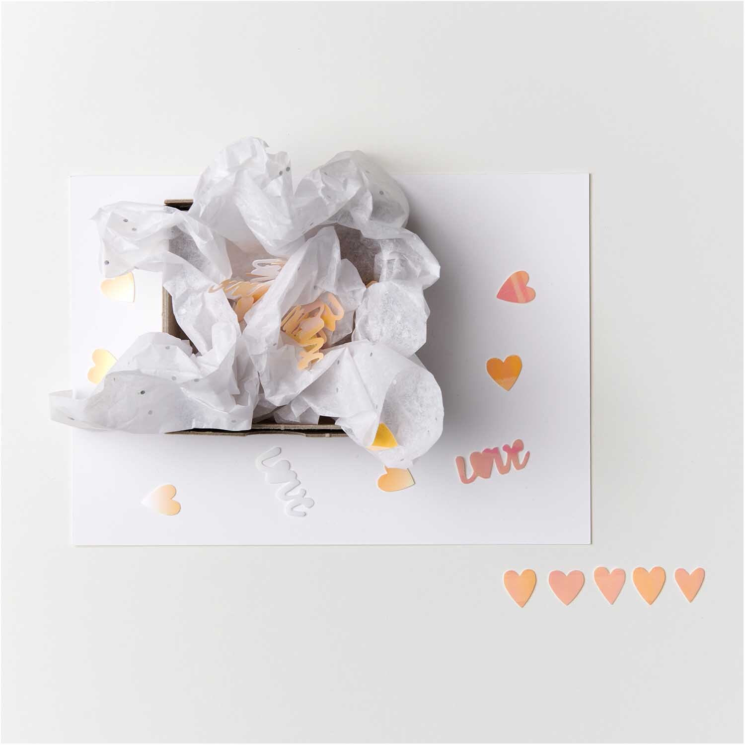 Flitter Love Irisierend 100 Stück von Rico Design Flitter Love Irisierend: Herzkonfetti in zarten Farben auf weißem Hintergrund, ideal für Dekorationen.
