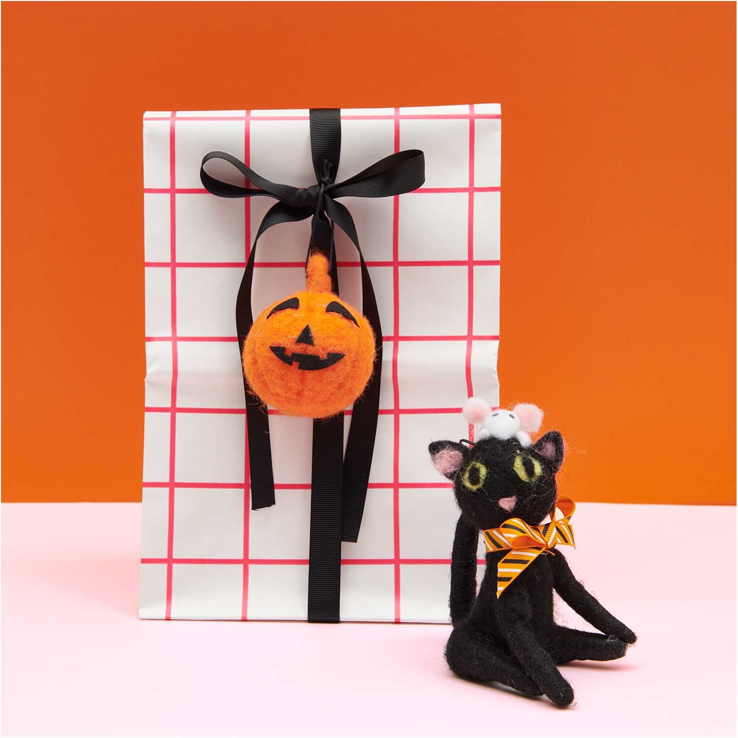 Kürbis handgefilzt orange 7x8cm von Rico Design Kürbis handgefilzt orange 7x8cm, dekorativ an Geschenk mit schwarzem Band, neben Filzkatze.