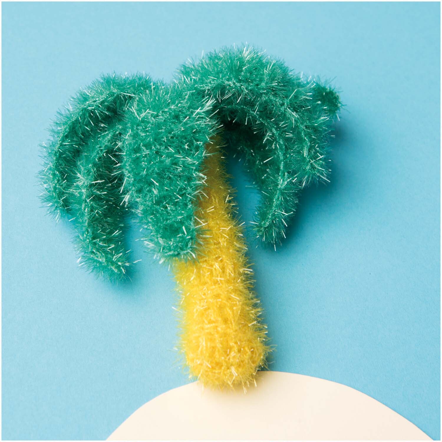 Creative Bubble - At the Beach: Strickgarn in Form einer Palme auf blauem Hintergrund, von Rico Design.