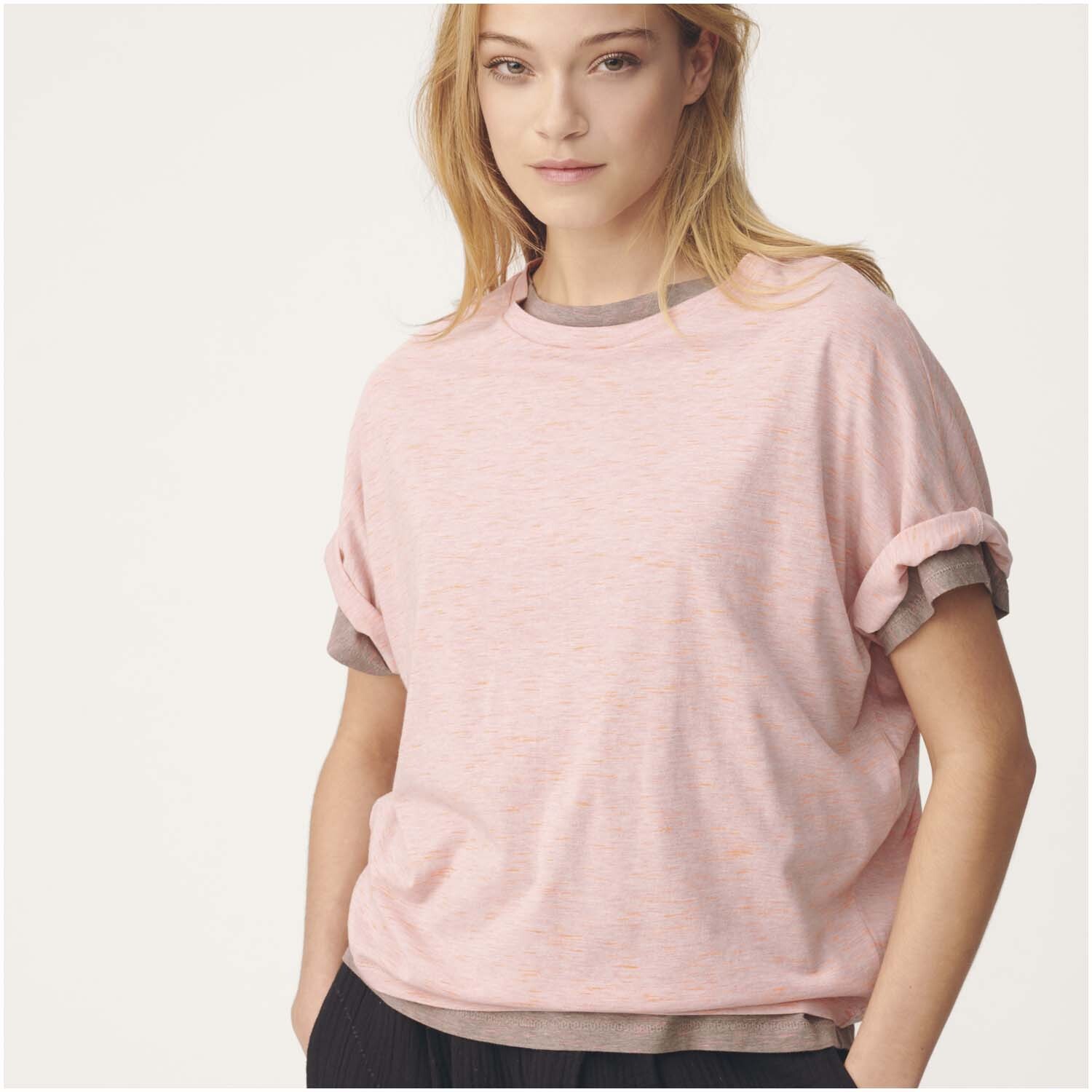 Stoffabschnitt Jersey pfirsich-neonorange 80x100cm von Rico Design Stoffabschnitt Jersey pfirsich-neonorange 80x100cm von Rico Design, getragen von Frau in lässigem T-Shirt-Stil.