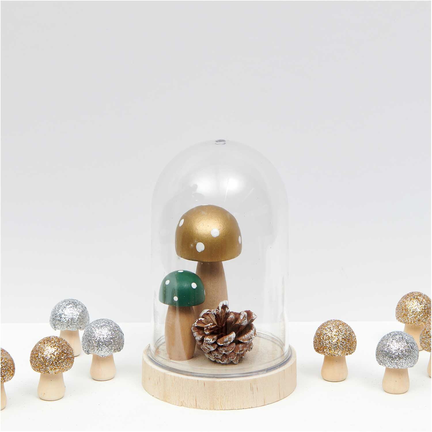 3D-Holzstreu Pilz mit Glitter silber 30x23mm 6 Stück von Rico Design 3D-Holzstreu Pilz mit Glitter silber, dekorative Pilze in einer Glaskuppel, umgeben von weiteren glitzernden Pilzen auf weißem Hintergrund.
