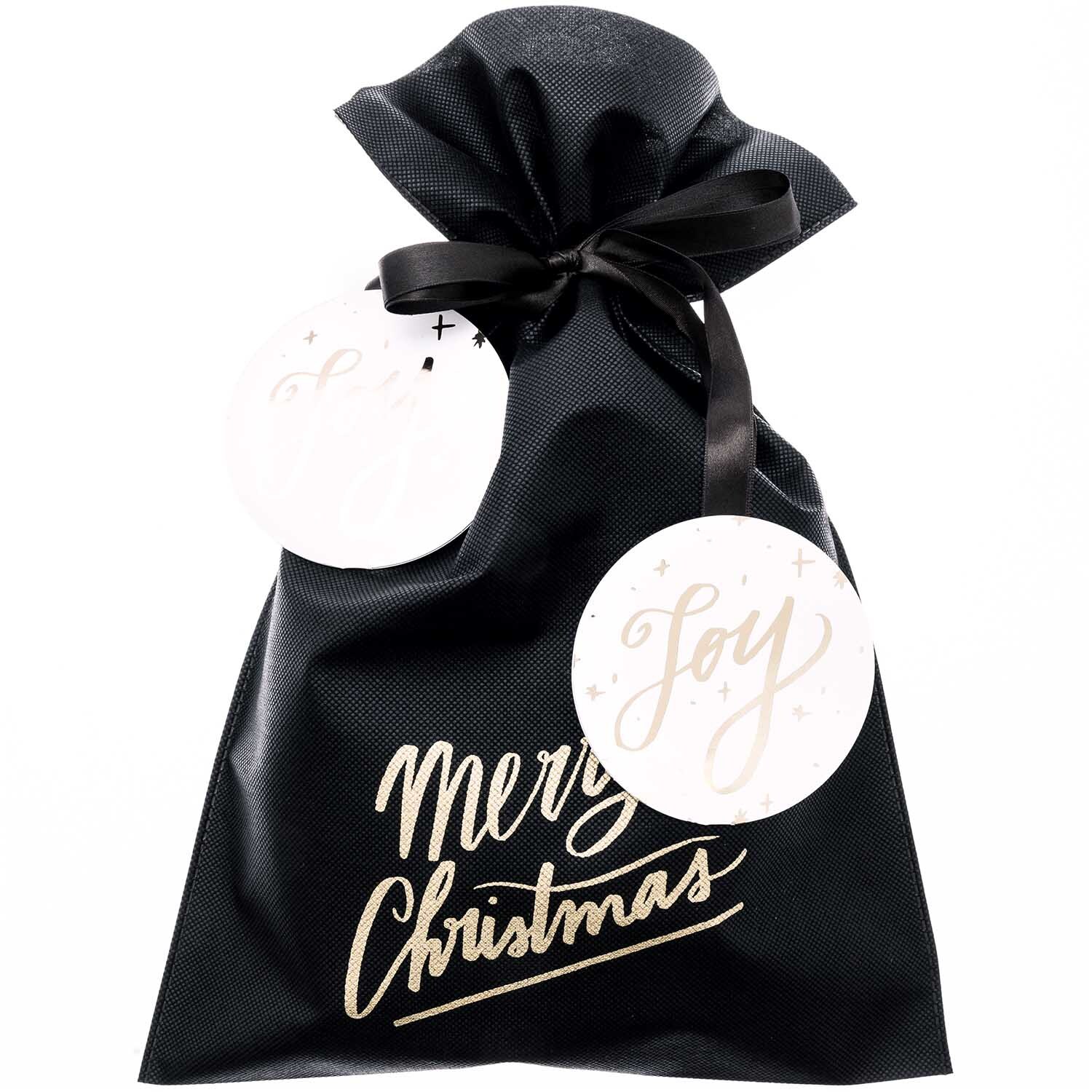 Paper Poetry Geschenktüte Merry Christmas in Schwarz mit festlichem Schriftzug und dekorativen Anhängern. Ideal für stilvolle Weihnachtsgeschenke.