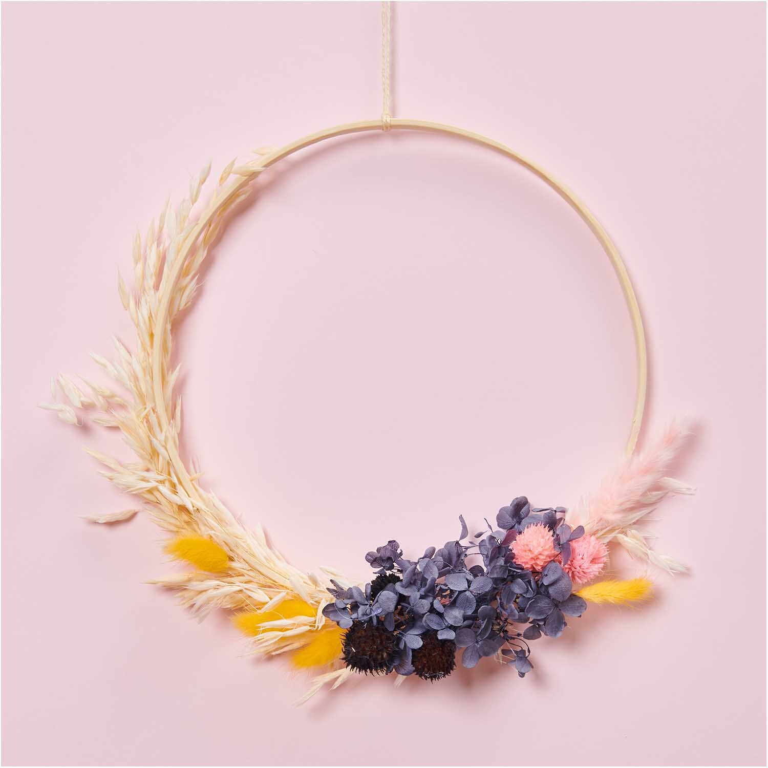 Trockenblumenstrauß pastell-schwarz 30cm von Rico Design: Eleganter Kranz mit bunten Trockenblumen auf rosa Hintergrund, 13-teilig.