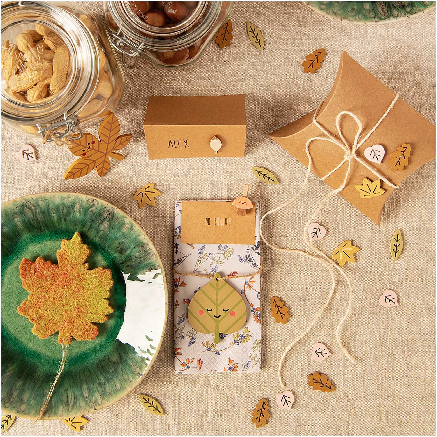 Filzhänger Herbstblatt 9x10cm von Rico Design Filzhänger Herbstblatt 9x10cm auf einem Tisch mit herbstlichen Dekorationen und Geschenkverpackungen.