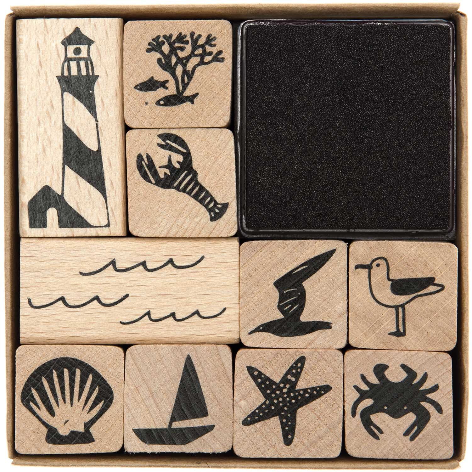 Paper Poetry Stempelset Maritim, 11-teilig, mit maritimen Motiven wie Leuchtturm, Krabbe und Möwe auf Holzstempeln. Ideal für kreative Projekte.
