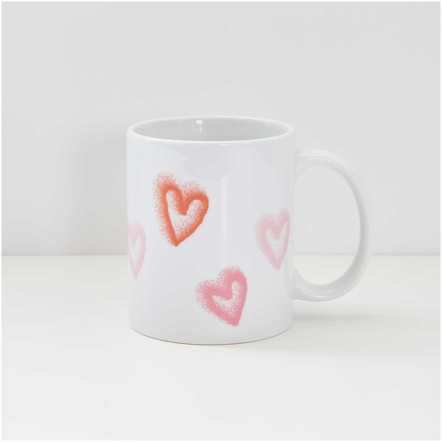 Transfermotiv Spray Herzen 12 Stück von Rico Design Transfermotiv Spray Herzen: Weiße Tasse mit roten und rosa Herzmotiven, ideal für kreative Designs. Marke: Rico Design.