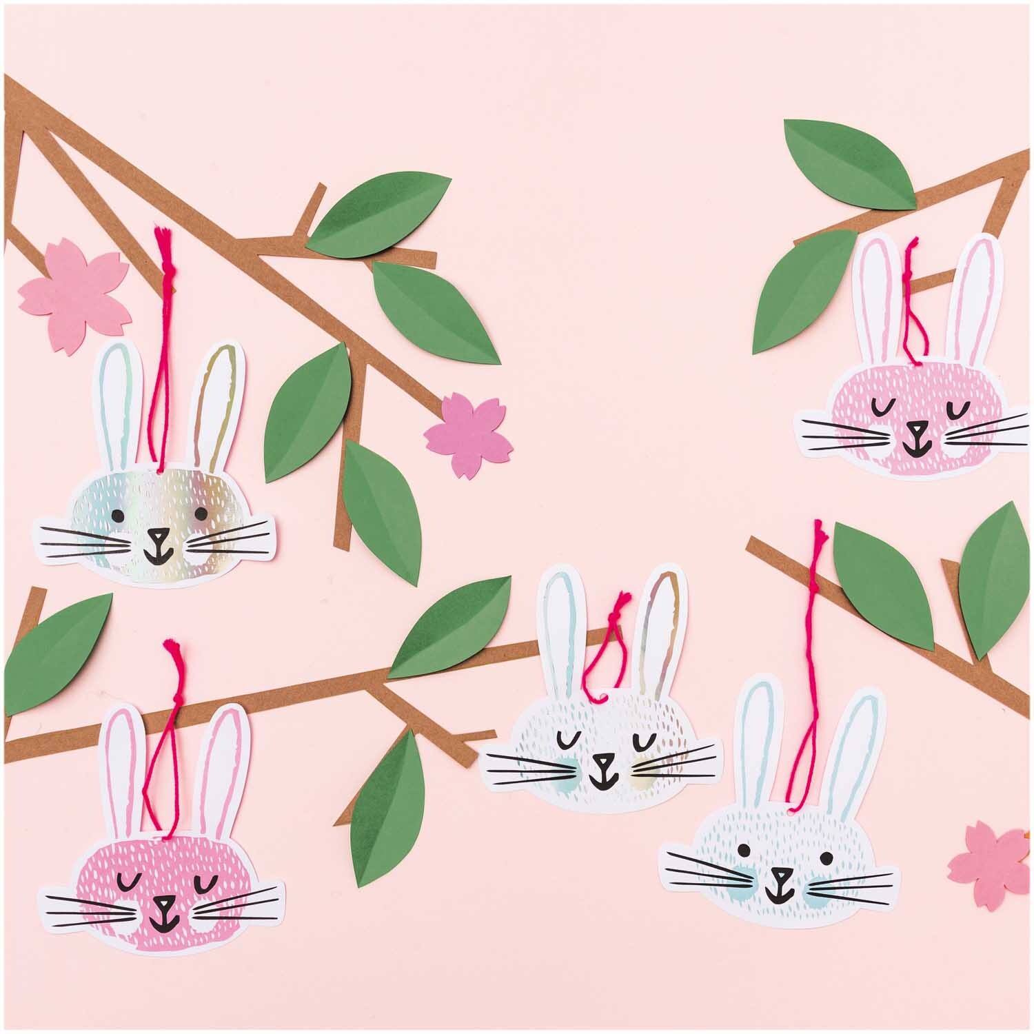 Paper Poetry Papieranhänger Hasengesichter, 8 Stück, an Zweigen hängend, in Rosa und Weiß. Ideal für kreative Dekorationen.