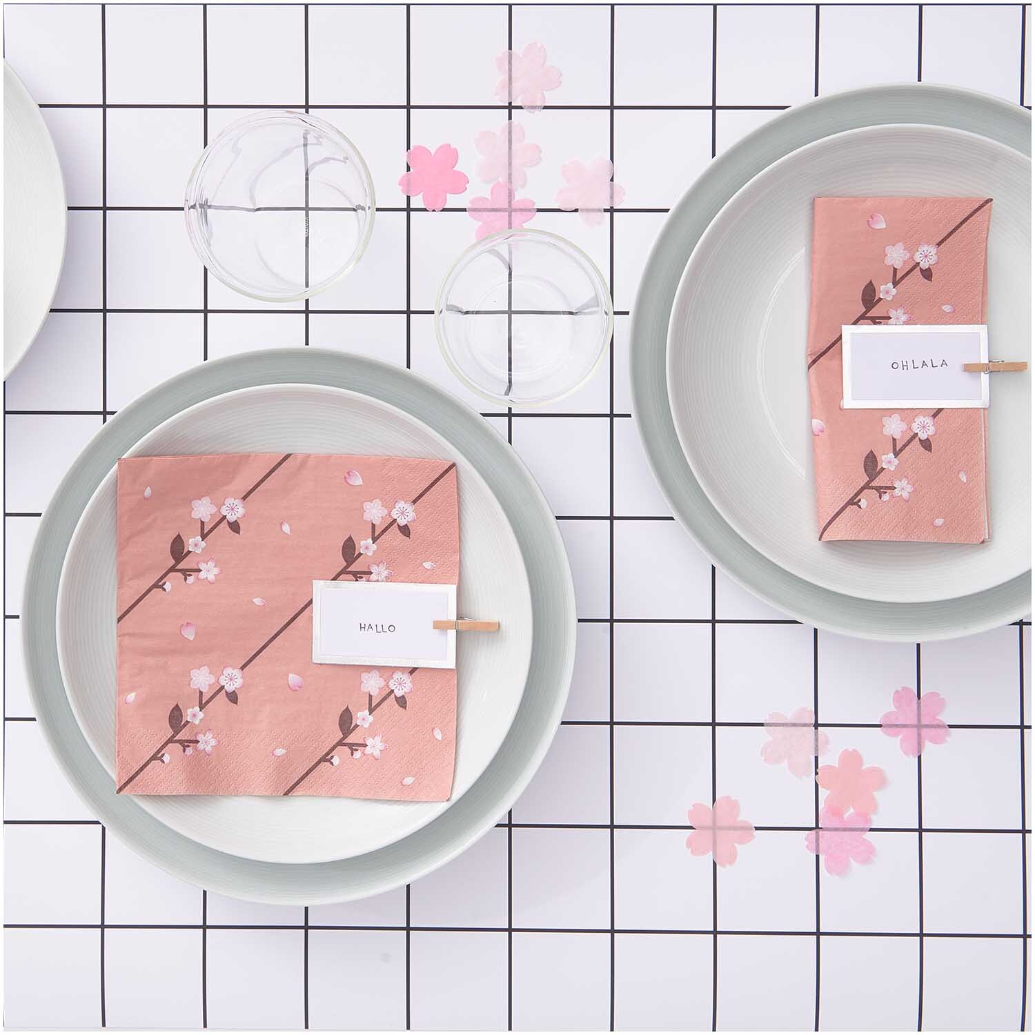 Konfetti Kirschblüten pastell rosa Mix 20g auf einem gedeckten Tisch mit rosa Servietten und Geschirr. Ideal für festliche Anlässe.